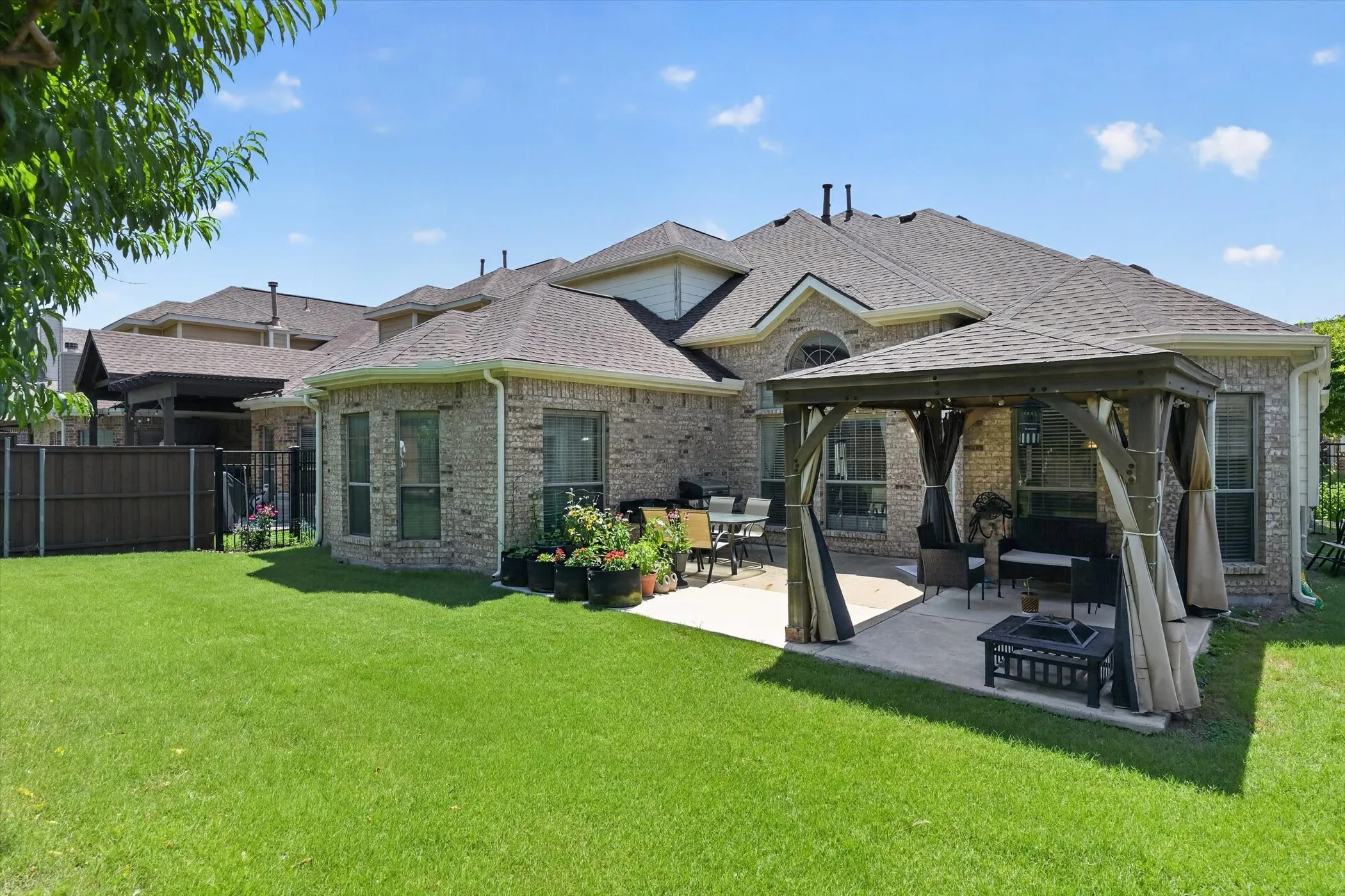 Expansive green lawn with a covered patio featuring a gazebo