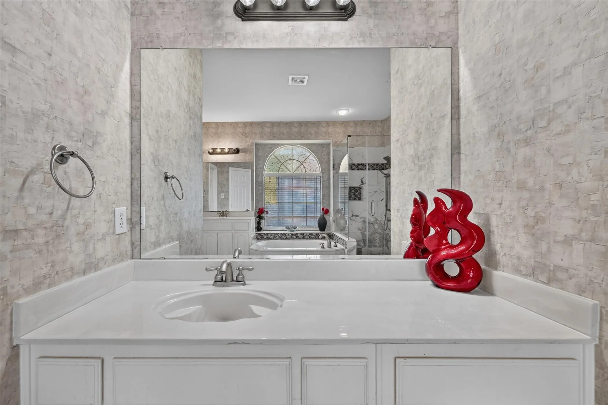 Bathroom vanity featuring an integrated sink, white countertop, and brushed nickel faucet