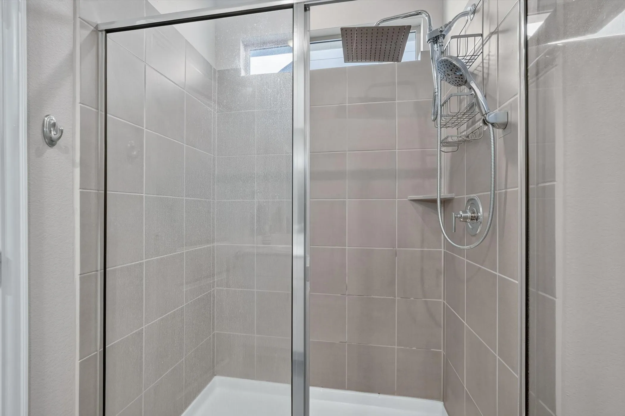Shower enclosure featuring glass panels with chrome framing