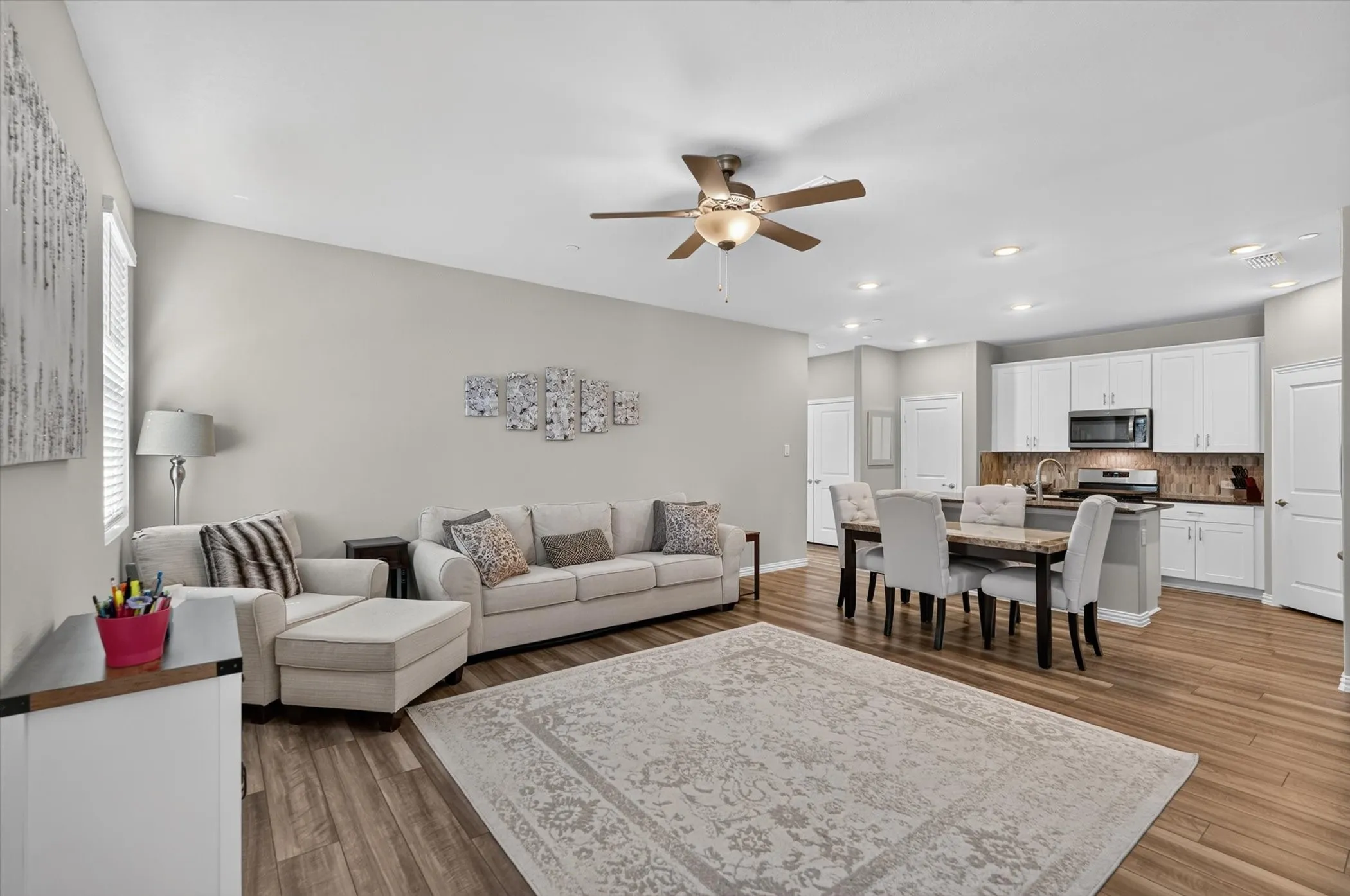 Open-concept living space featuring wood-finish flooring, recessed lighting, and a ceiling fan