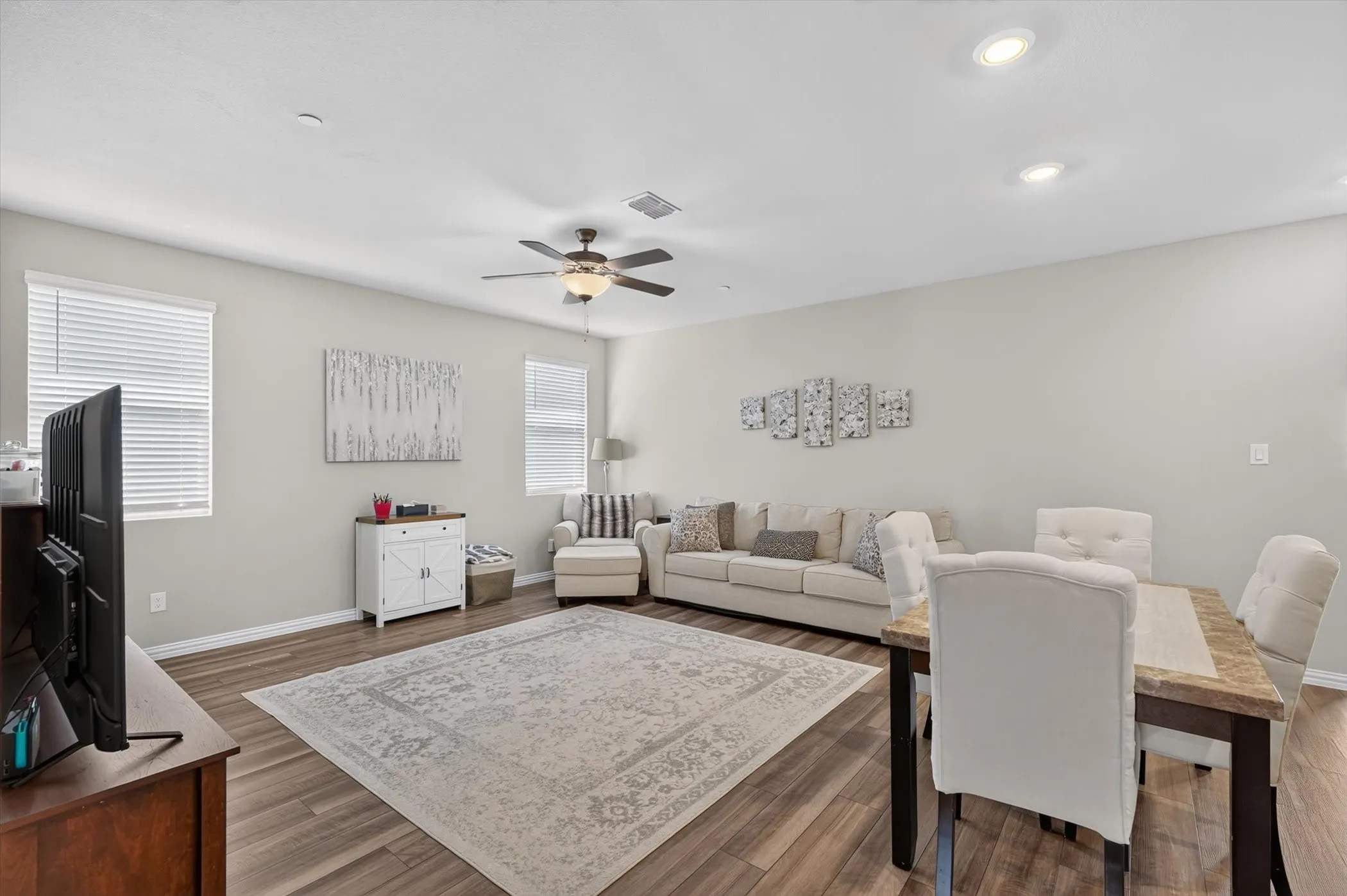 Open-concept living area featuring wood-finish flooring, recessed lighting, and a ceiling fan