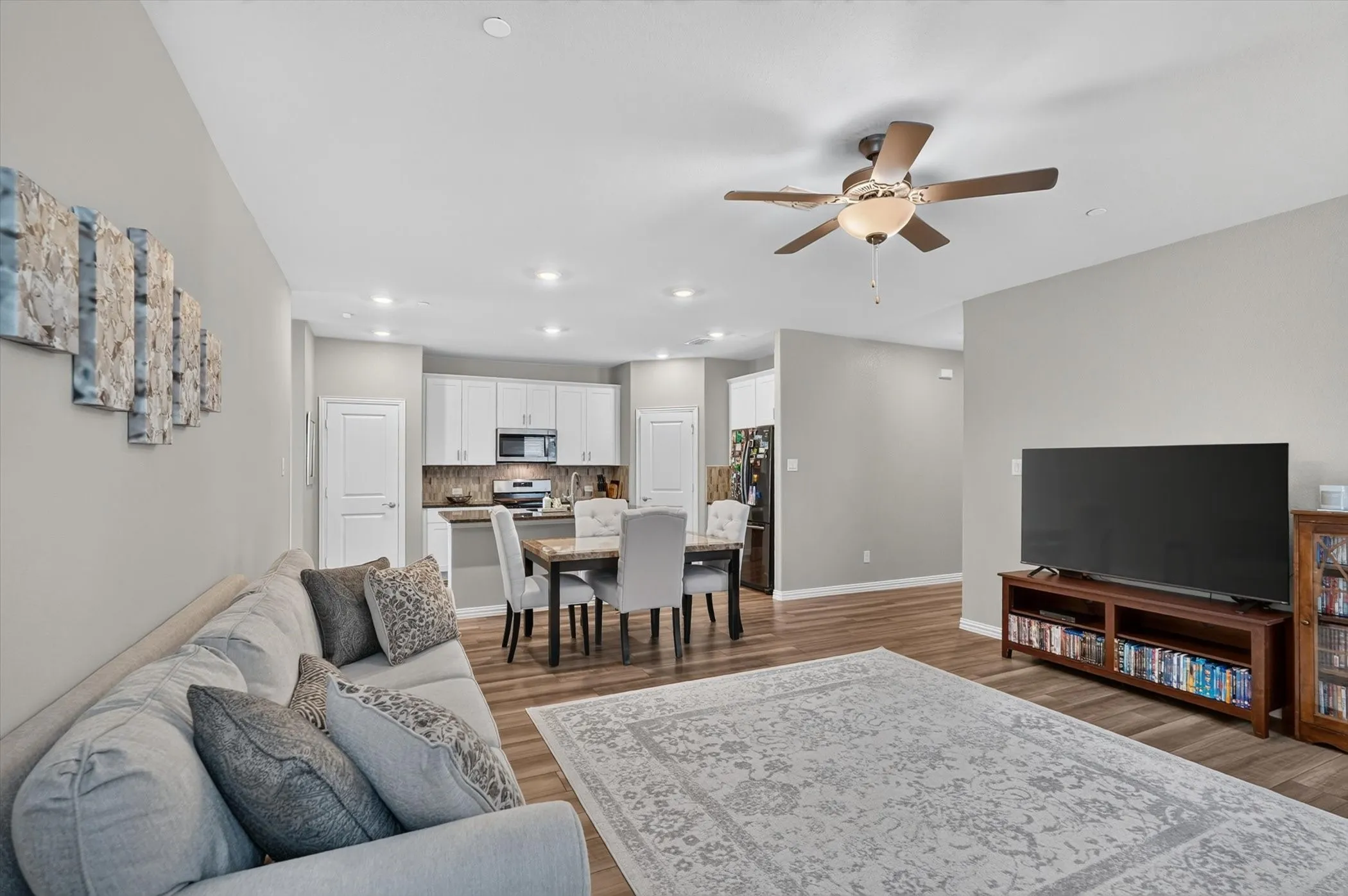 Open-concept living area featuring wood-finish flooring, recessed lighting, and a ceiling fan