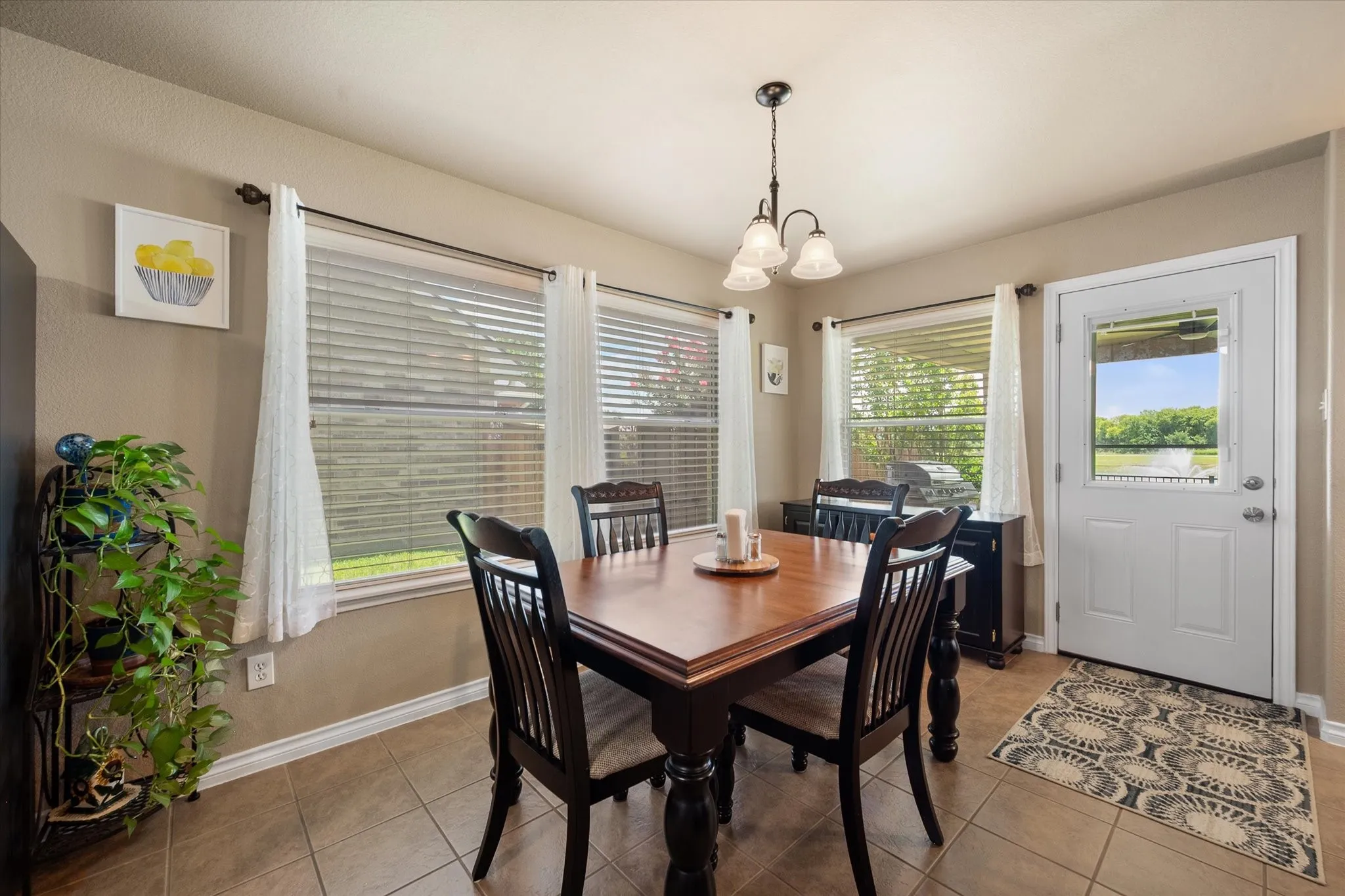 Start your day in this bright and inviting breakfast room, where large windows fill the space with natural light and showcase peaceful backyard views. Perfectly positioned just off the kitchen, this dining area offers a seamless flow for casual meals, morning coffee, or entertaining family and friends. Enjoy relaxing views of the covered patio, landscaped backyard, and tranquil pond, creating a serene backdrop for everyday living. With easy outdoor access and an open-concept layout, this breakfast nook blends comfort, functionality, and scenic charm.