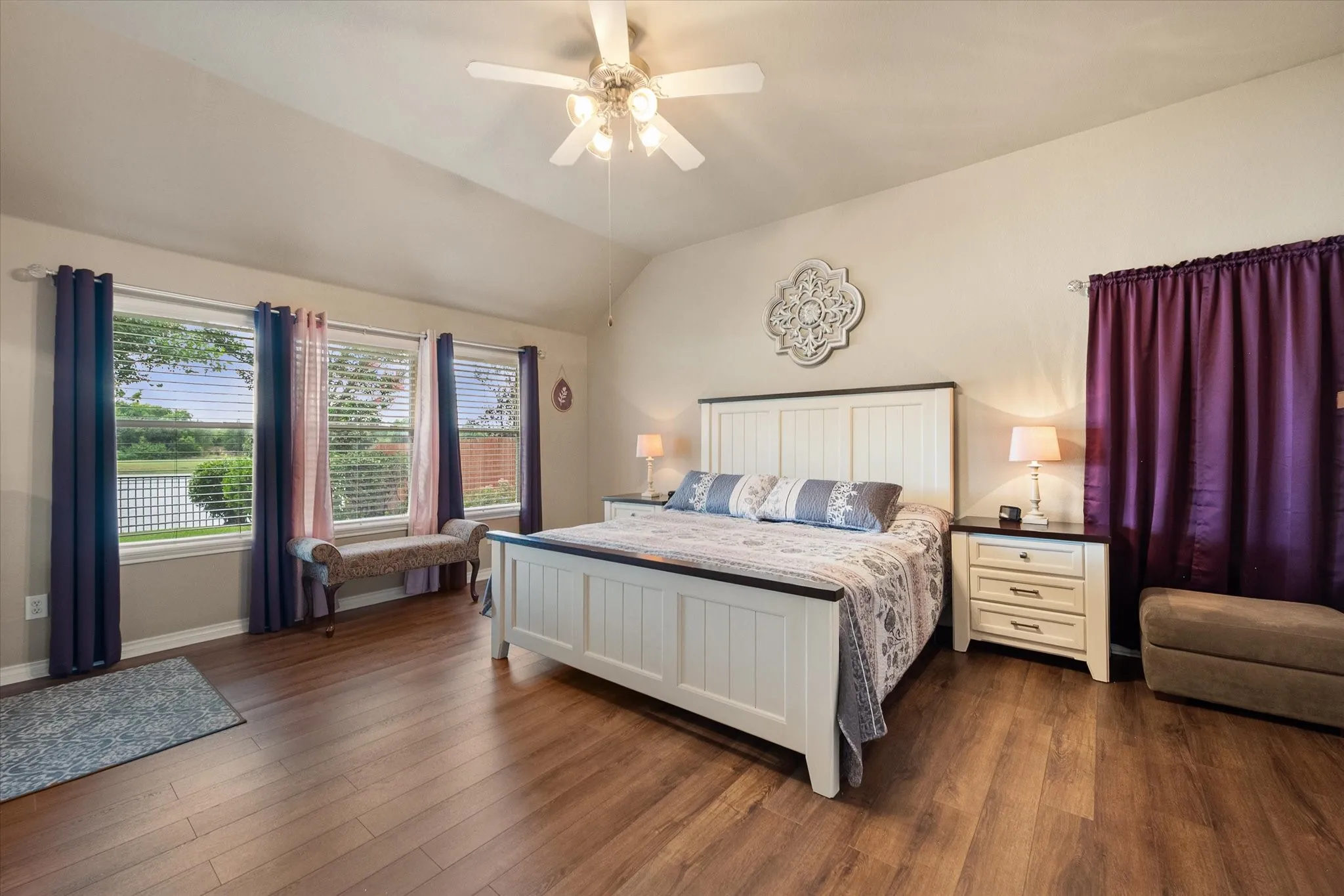 Retreat to this spacious primary bedroom, featuring soaring high ceilings, durable luxury vinyl plank flooring, and a bright, airy design that creates a relaxing atmosphere. Large windows fill the room with natural light while showcasing expansive backyard views with no rear neighbors, offering exceptional privacy and a peaceful setting. A ceiling fan provides year-round comfort, and the generous layout easily accommodates a king-size bed with additional seating. This inviting owner's suite blends comfort, style, and tranquility, making it the perfect private retreat.
