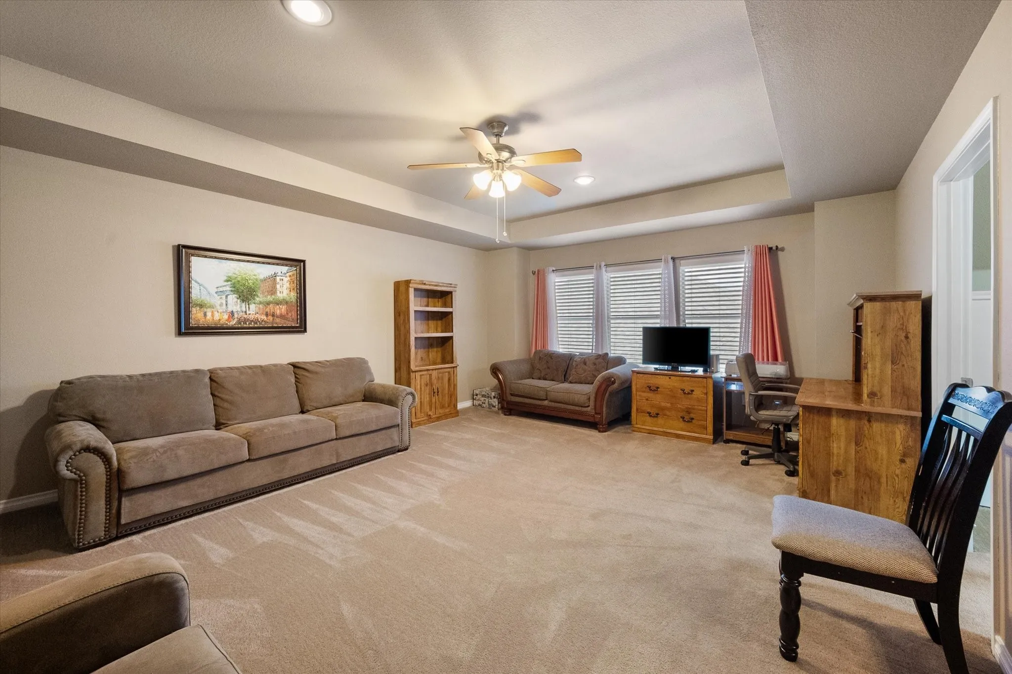 This expansive upstairs gameroom offers exceptional flexible living space designed to adapt to your lifestyle. Large enough to serve as a media room, game room, family room, playroom, home office, homeschool area, fitness space, or second living area, this versatile retreat provides endless possibilities. A tray ceiling, ceiling fan, recessed lighting, and abundant natural light create a bright and inviting atmosphere, while the open layout easily accommodates multiple seating and activity zones. Conveniently located upstairs near the secondary bedrooms, this multi-purpose space is ideal for entertaining, relaxing, working from home, or creating the perfect recreation area.