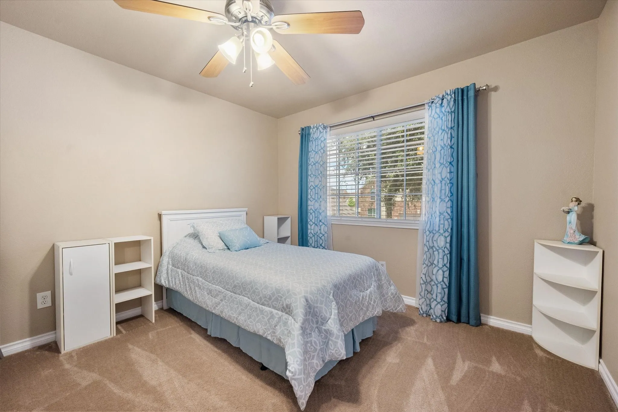 This spacious upstairs secondary bedroom features a desirable split-bedroom design, providing added privacy and separation from the primary suite. Filled with natural light, the room offers plush carpeting, a ceiling fan, and generous dimensions that easily accommodate a full or queen-size bedroom set with space for a desk or sitting area. Neutral finishes create a bright, move-in-ready space that's perfect for children, guests, or a home office, while the thoughtful upstairs layout enhances comfort and privacy for every member of the household.