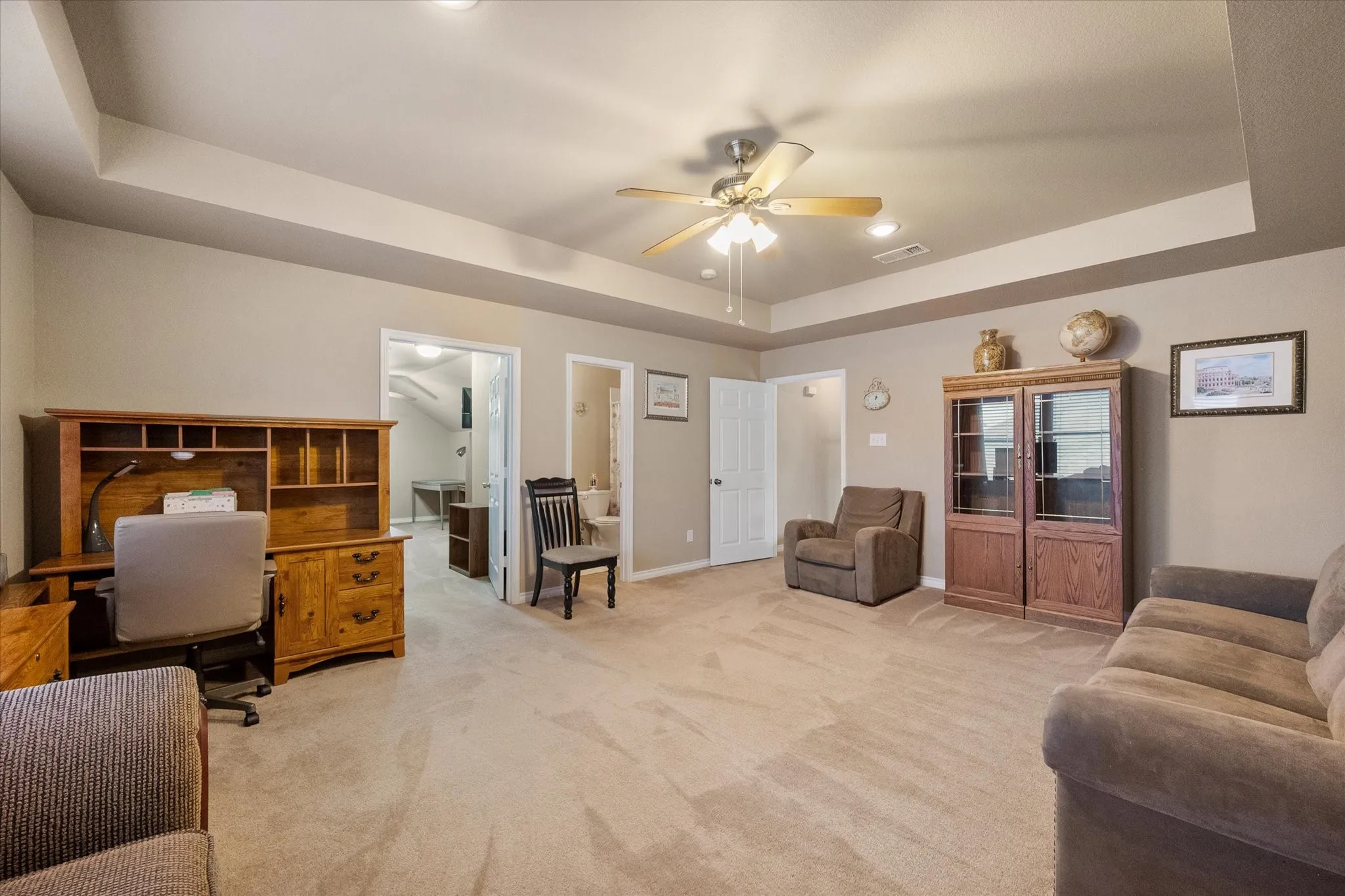 The spacious upstairs gameroom offers exceptional flexible living space that can easily adapt to your family's changing needs. Whether you're envisioning a media room, game room, second living area, playroom, home office, homeschool space, fitness room, or hobby area, this oversized bonus room provides endless possibilities. Featuring a tray ceiling, ceiling fan, recessed lighting, plush carpeting, and a bright open layout, the space is both comfortable and functional. Conveniently located near the upstairs secondary bedrooms and full bath, this versatile retreat is ideal for entertaining, relaxing, working from home, or creating the ultimate recreation space.