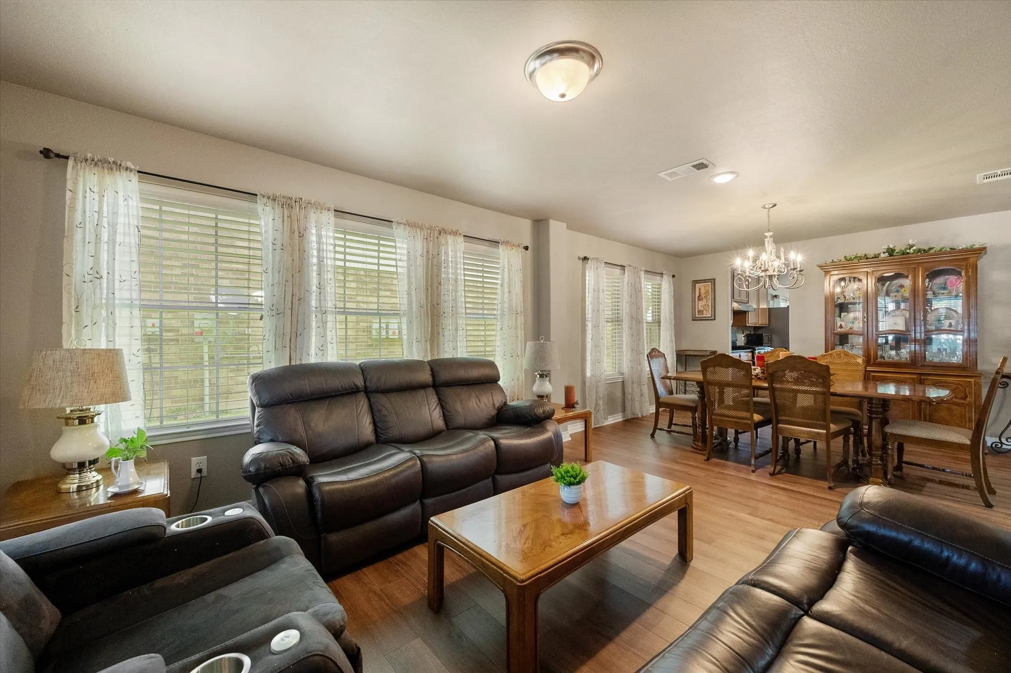 Ideal for entertaining, this formal living area is joined with the dining area creating the ability to expand for large gatherings. Walls of windows accented by 2 inch blinds steam natural light.