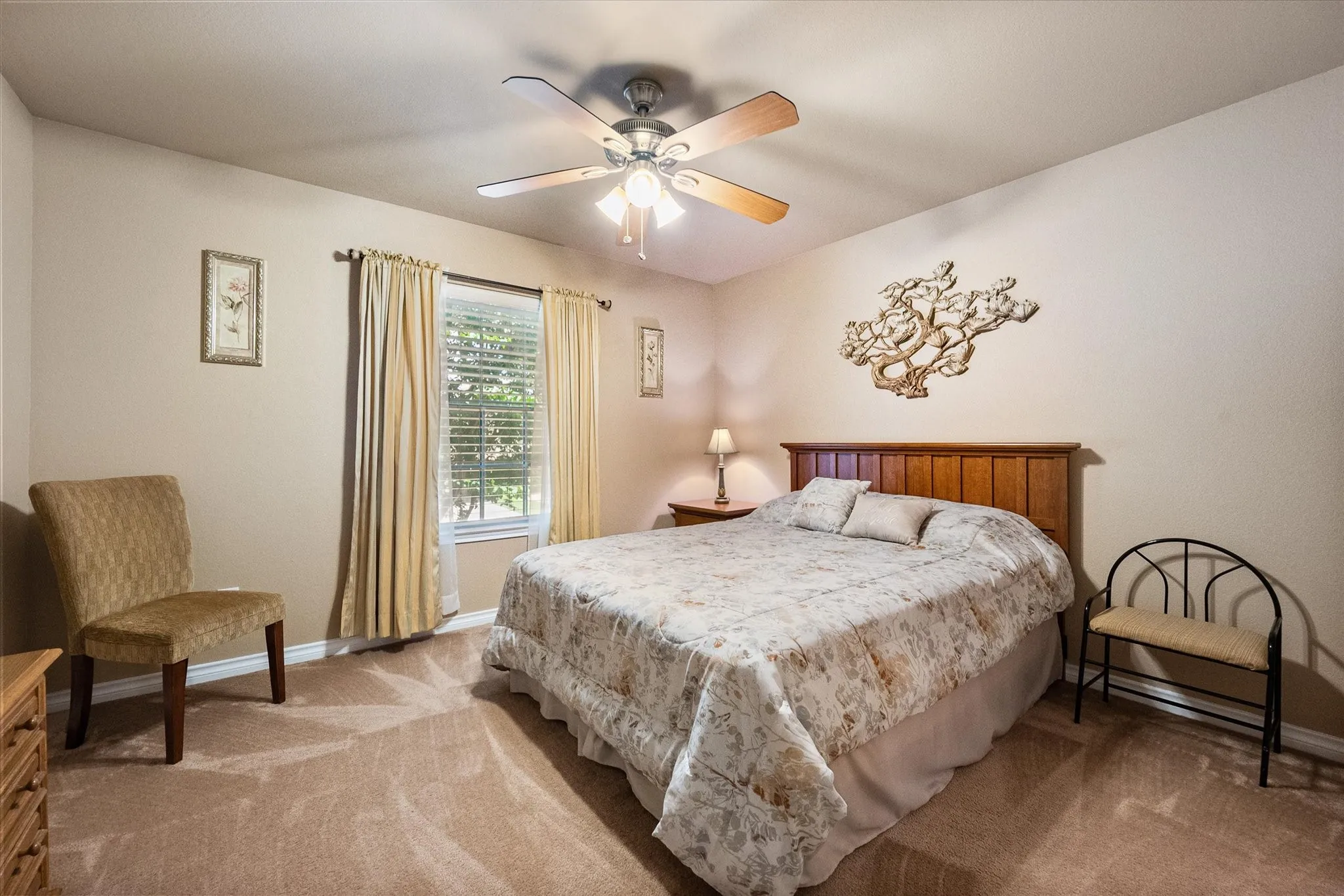 This oversized secondary bedroom offers exceptional space and versatility, easily accommodating a king-size bed with plenty of room for additional furniture. Featuring high ceilings, a ceiling fan, plush carpeting, and abundant natural light, this inviting bedroom creates a bright and comfortable retreat for family members or guests. Neutral paint tones provide a move-in-ready canvas, while the spacious layout makes it ideal as a guest suite, teen bedroom, or private home office.