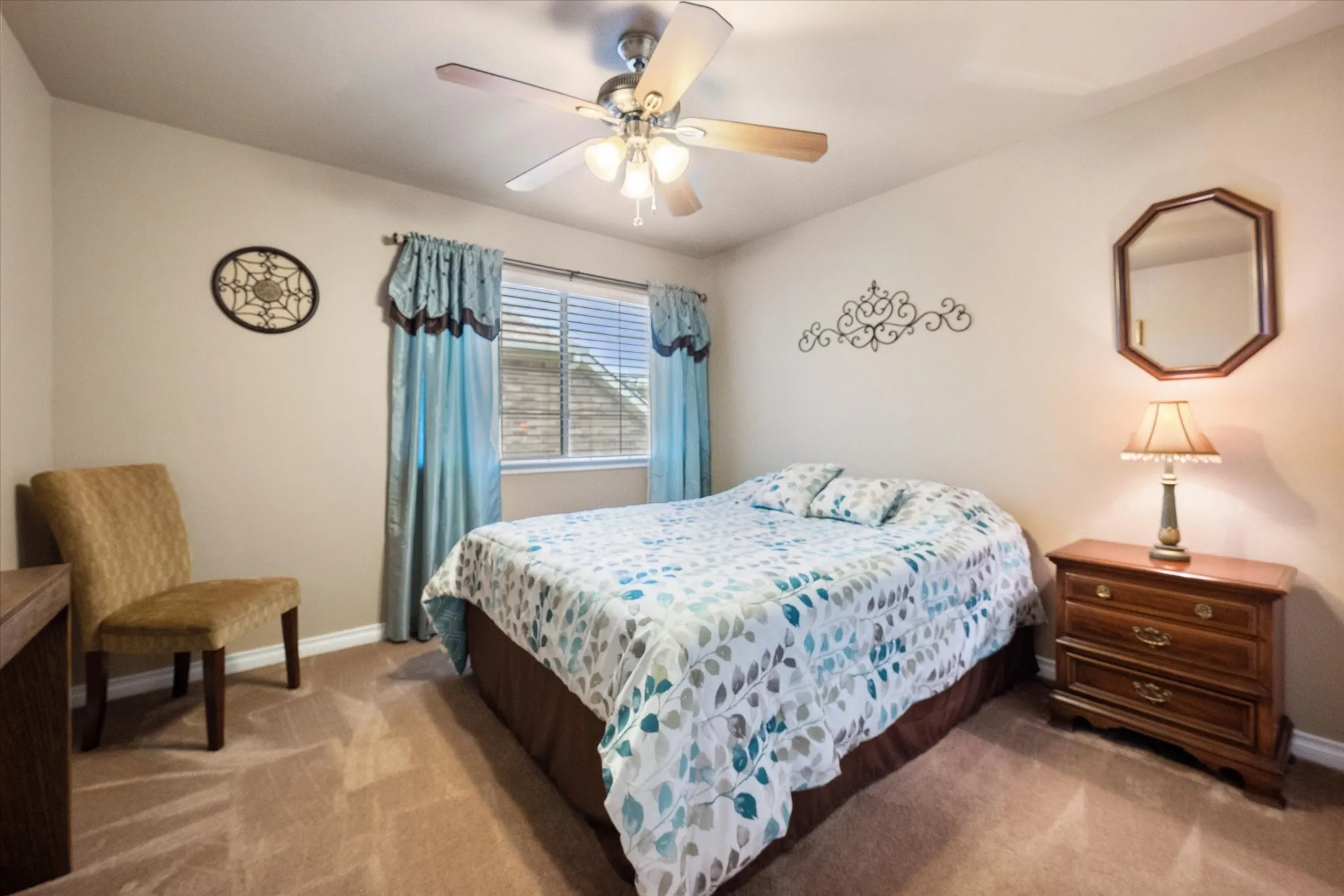 This spacious upstairs secondary bedroom offers a comfortable and versatile layout, perfect for family, guests, or a home office. Featuring plush carpeting, abundant natural light, and a ceiling fan for year-round comfort, the room provides plenty of space for larger furniture while maintaining a warm and inviting feel. Neutral finishes make it easy to personalize, creating a move-in-ready space that suits a variety of needs.