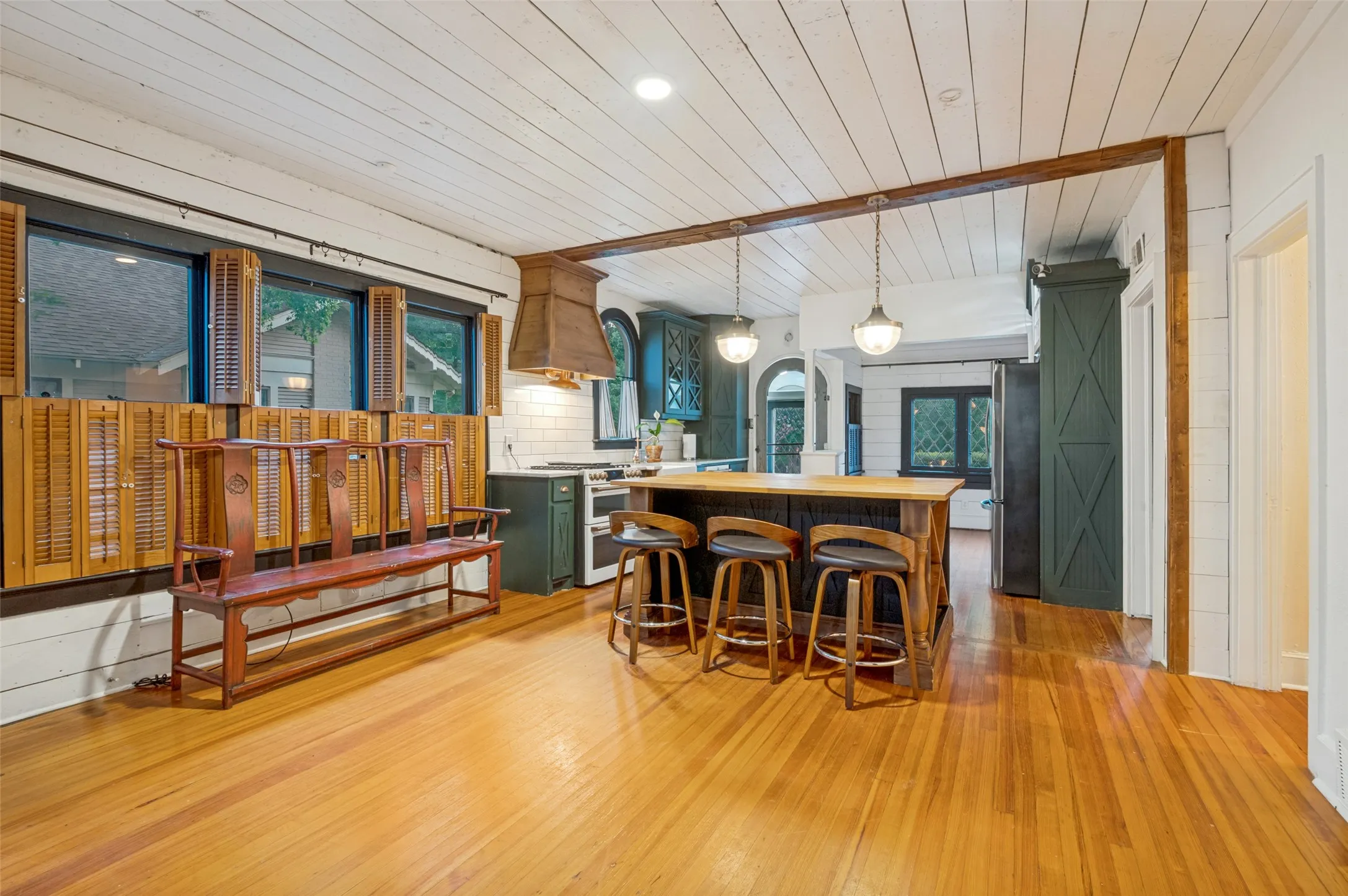 Open kitchen has large island with butcher block countertop.