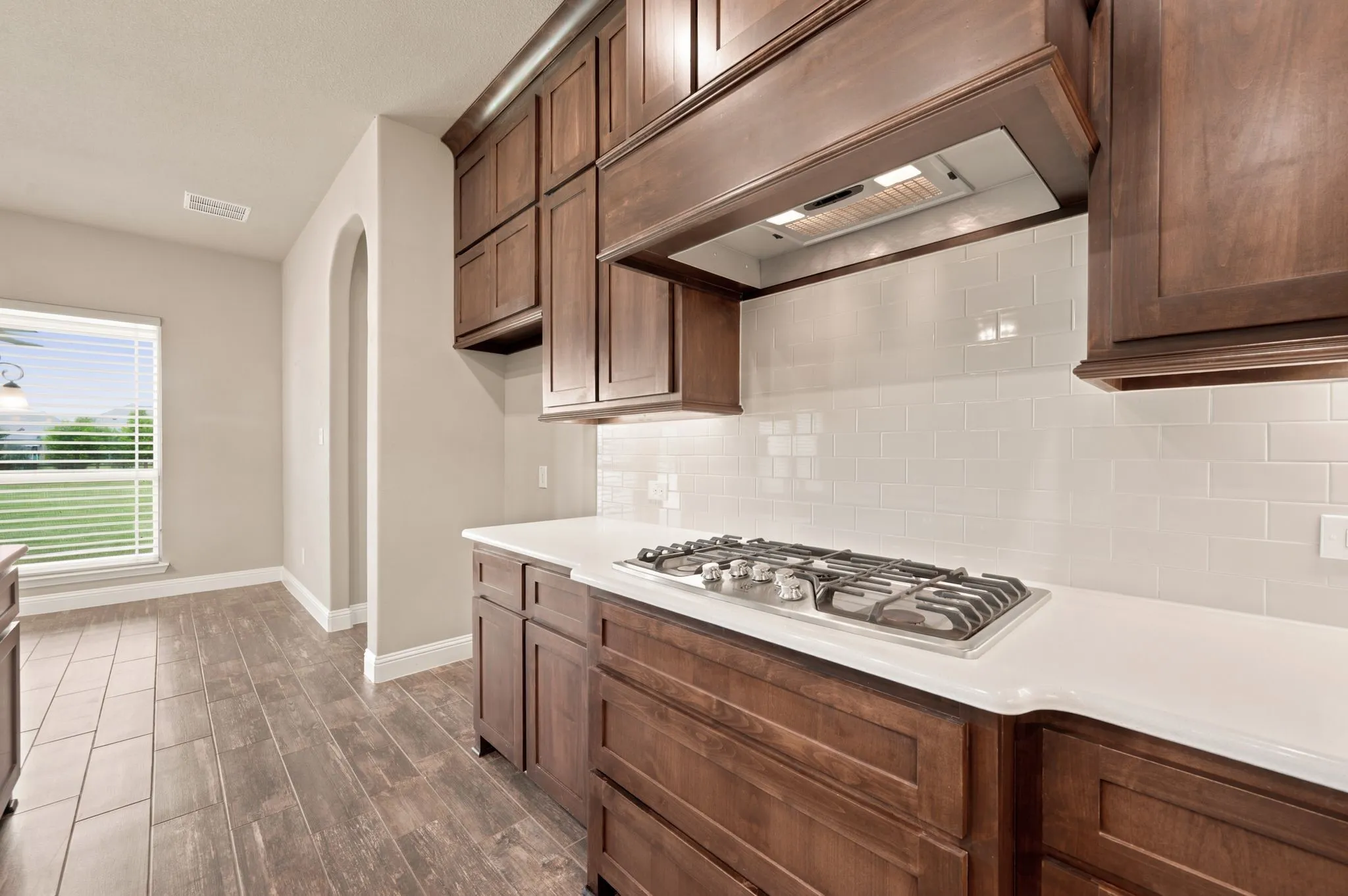 5 burner gas cooktop. Quartz counters. Subway tile backsplash. Custom cabinetry.