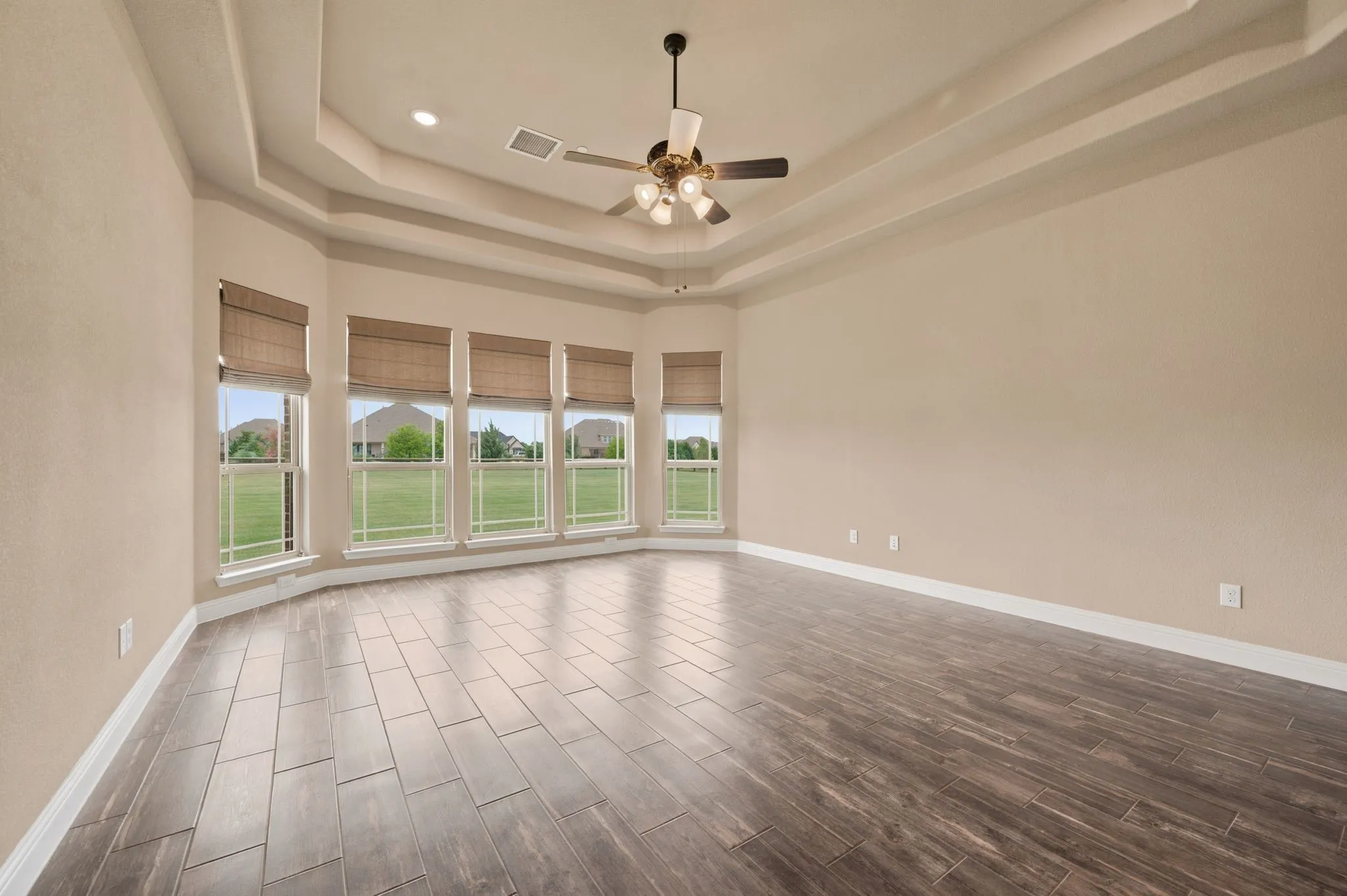 This large Primary Suite includes a trey ceiling and custom blinds.