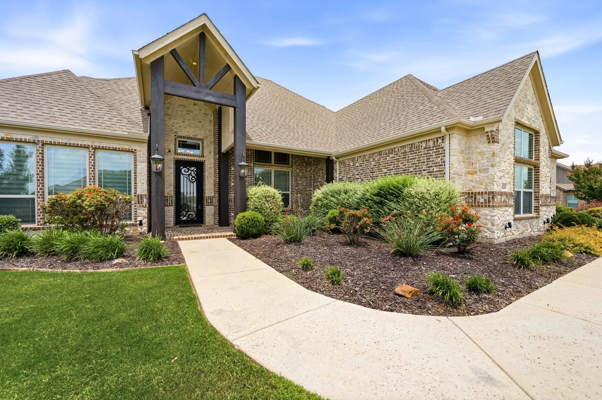 Coach and accent uplights.Covered front porch with cedar accents and a solid wood, glass and iron 8 ft door.