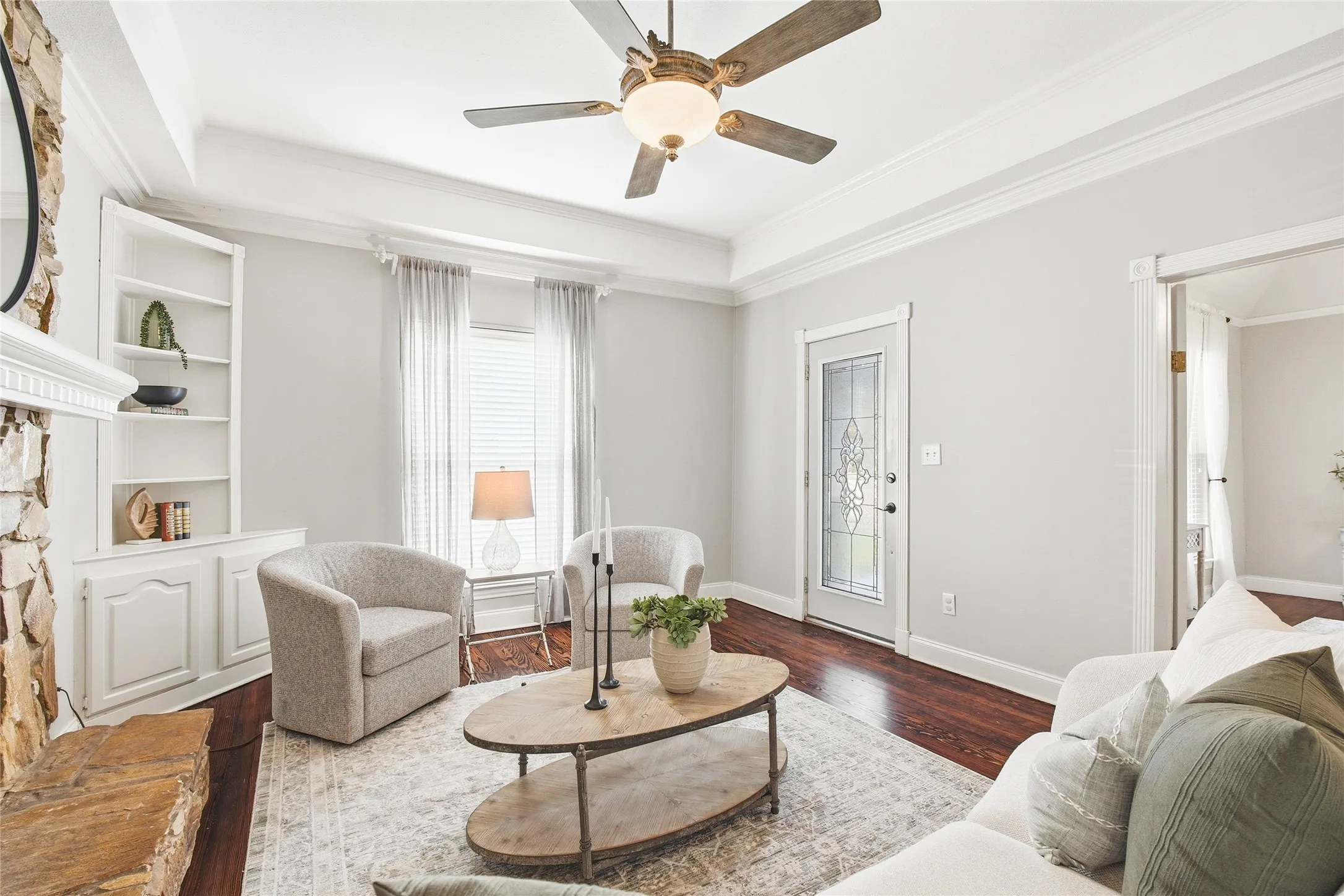 Family room with original hardwood floors and stone fireplace.