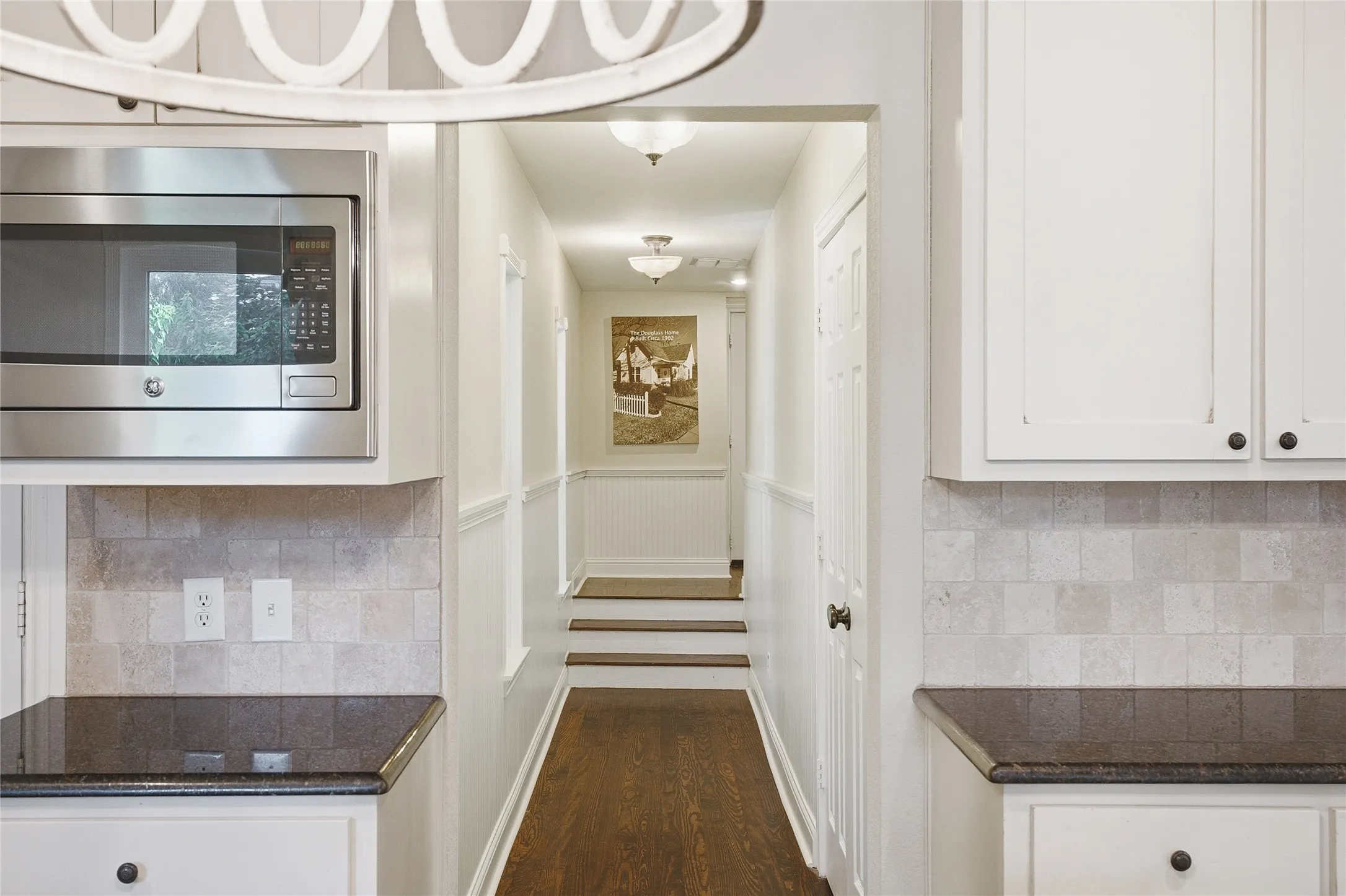 Hallway from kitchen to utility room on the right, garage and secondary at end of hall.