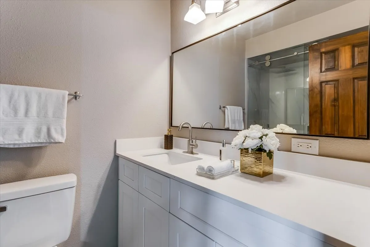 Bathroom vanity featuring a single undermount sink, a white countertop, and white shaker-style cabinetry
