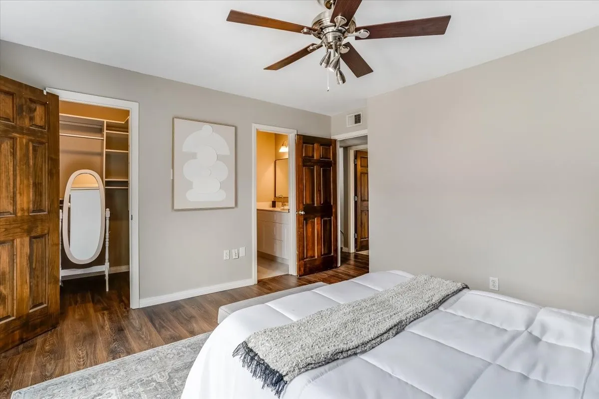 Bedroom featuring wood-finish flooring, a ceiling fan, and light gray walls