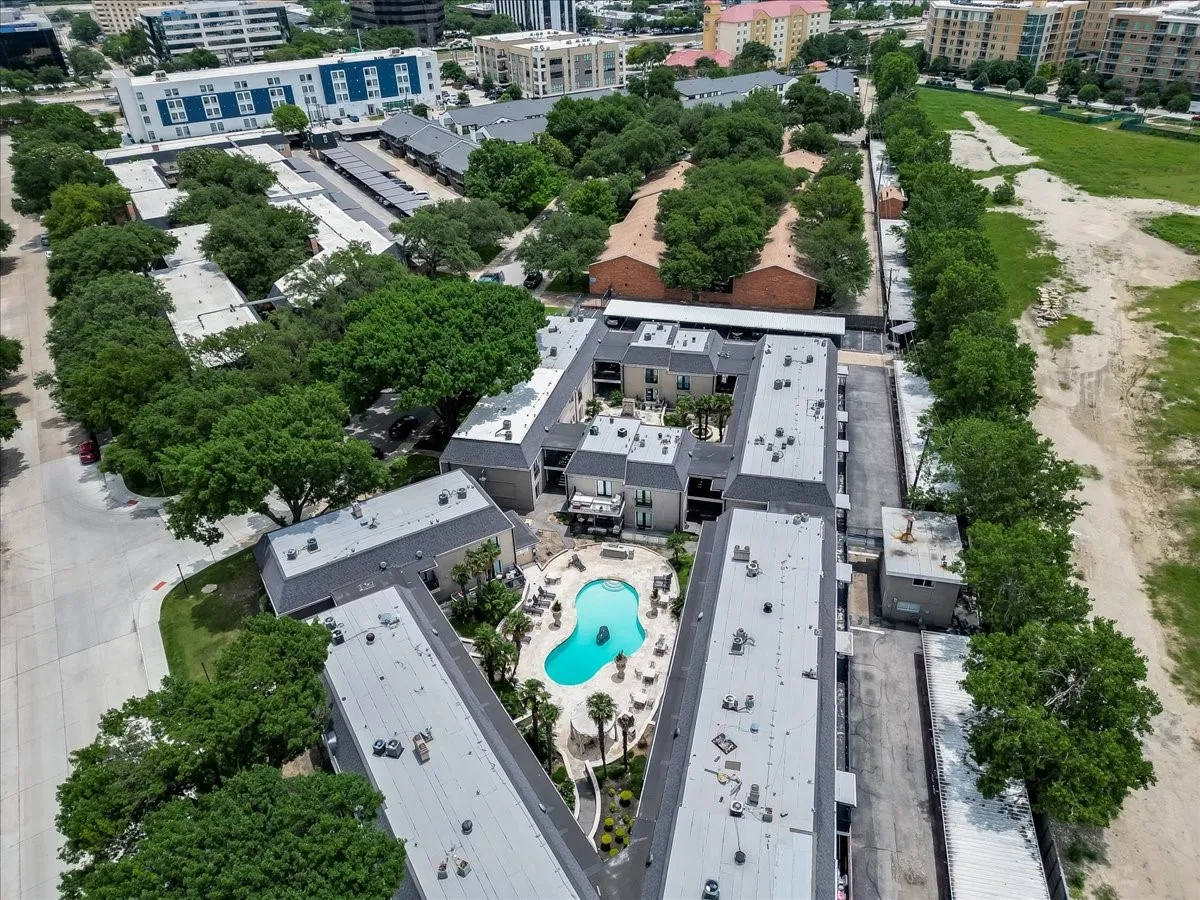 Aerial perspective showcasing a multi-building complex with a central swimming pool