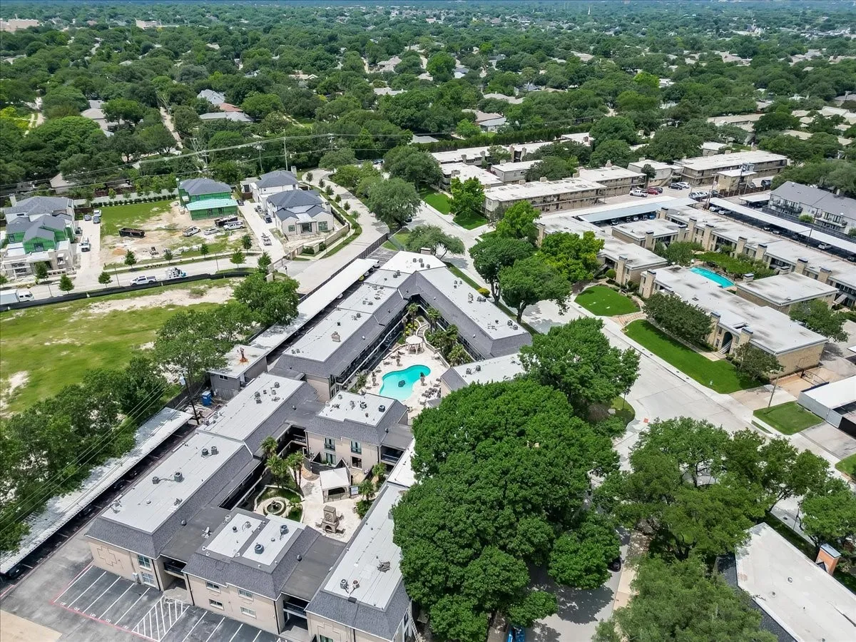Expansive property featuring multiple buildings with gray shingle roofs and light-colored exteriors