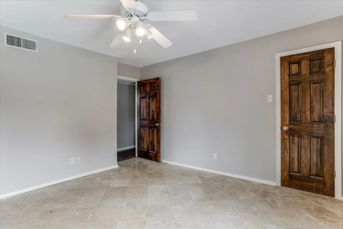 Neutral-toned wall finish with light-colored tile flooring