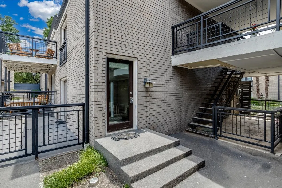 Exterior brick construction featuring a ground-level entrance with concrete steps