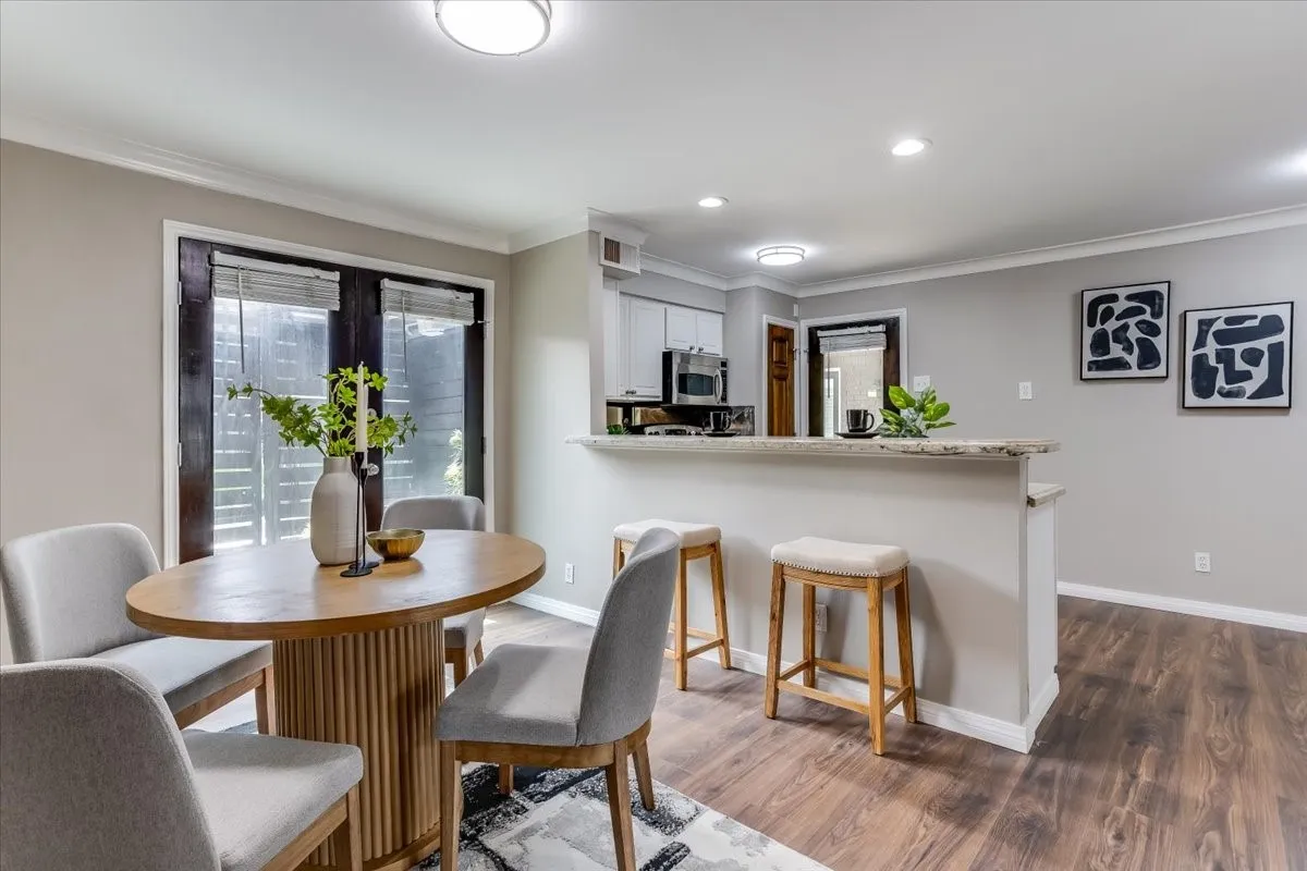Dining area with wood-finish flooring and a contemporary light fixture
