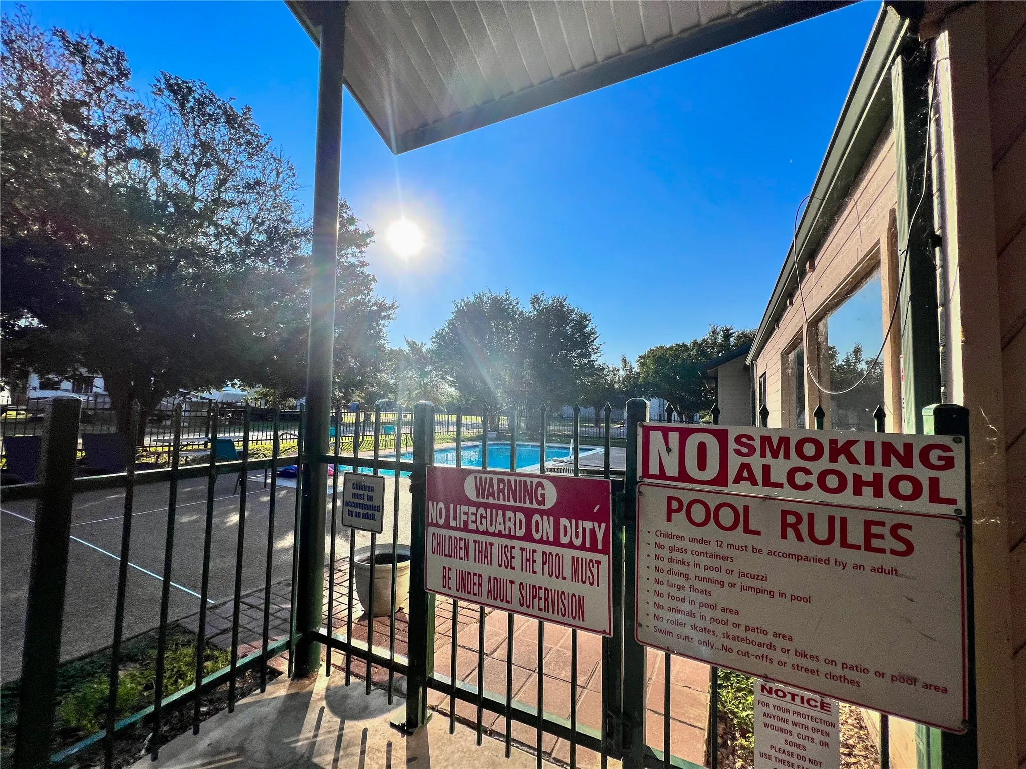 Posted pool rules and gated access at the Pelican Isle community pool.