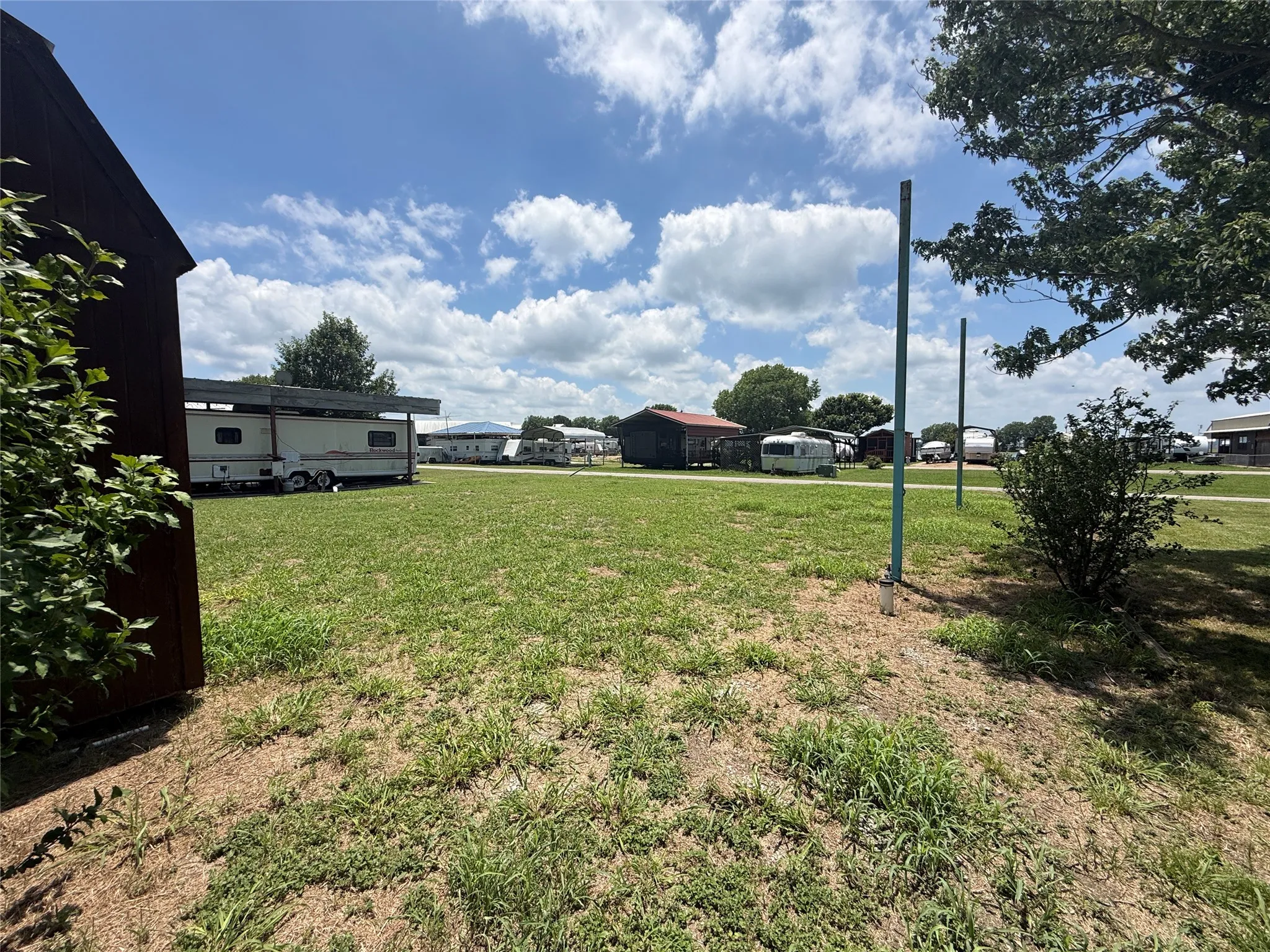 Open yard view with 3 poles installed for future covered parking.