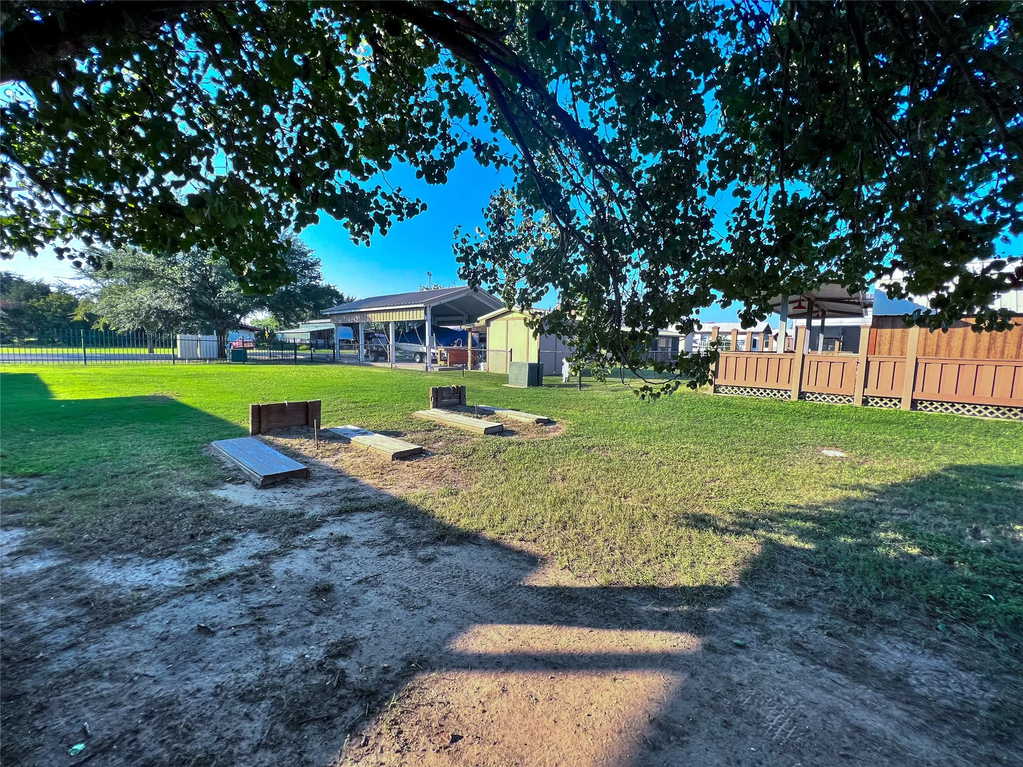 Horseshoe pits and recreation space shaded by mature trees.