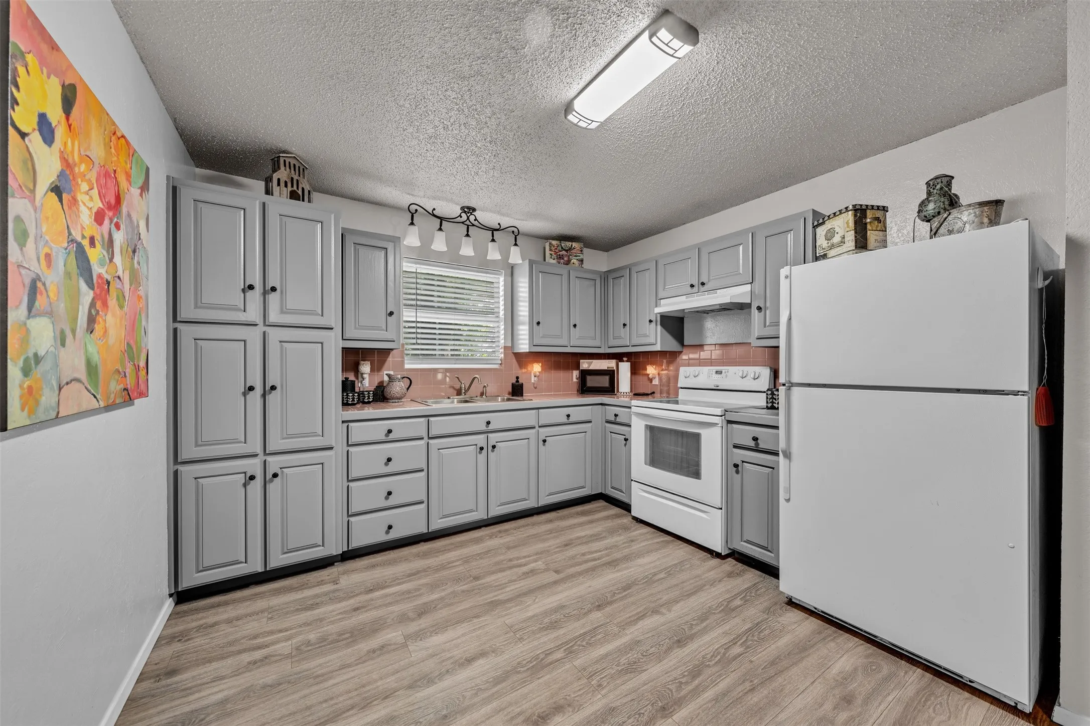 Kitchen featuring light gray cabinetry, wood-finish flooring, a white electric range, and a full-size refrigerator
