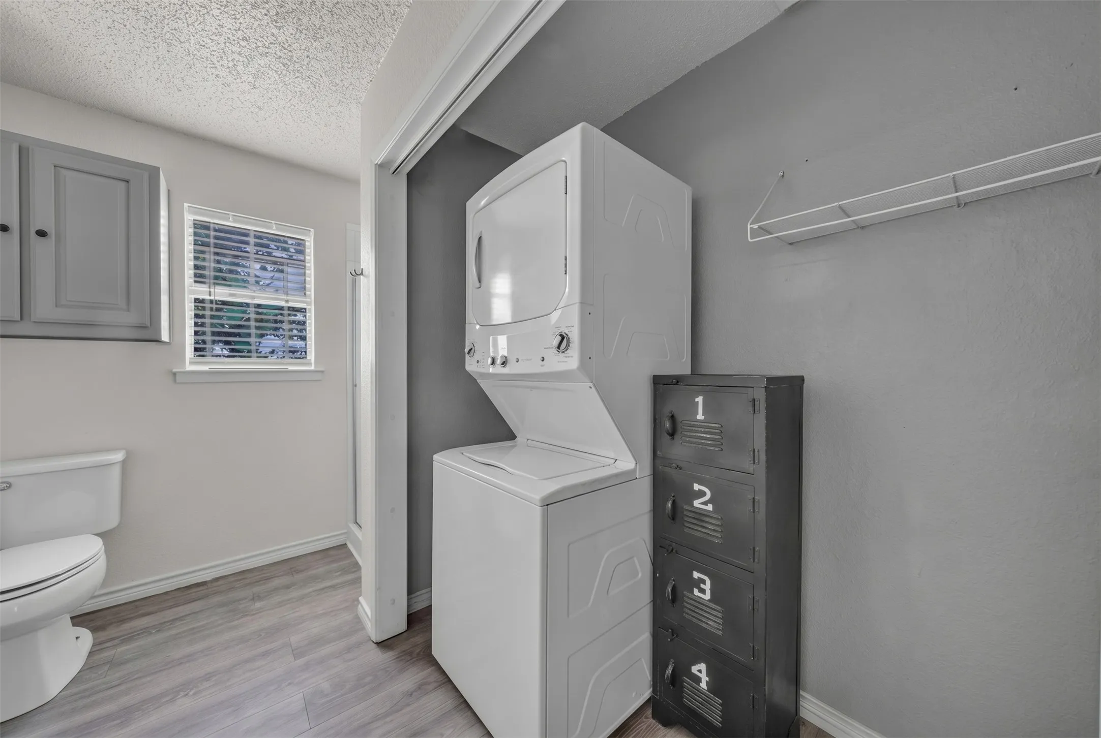 Dedicated laundry area featuring a stacked washer and dryer unit