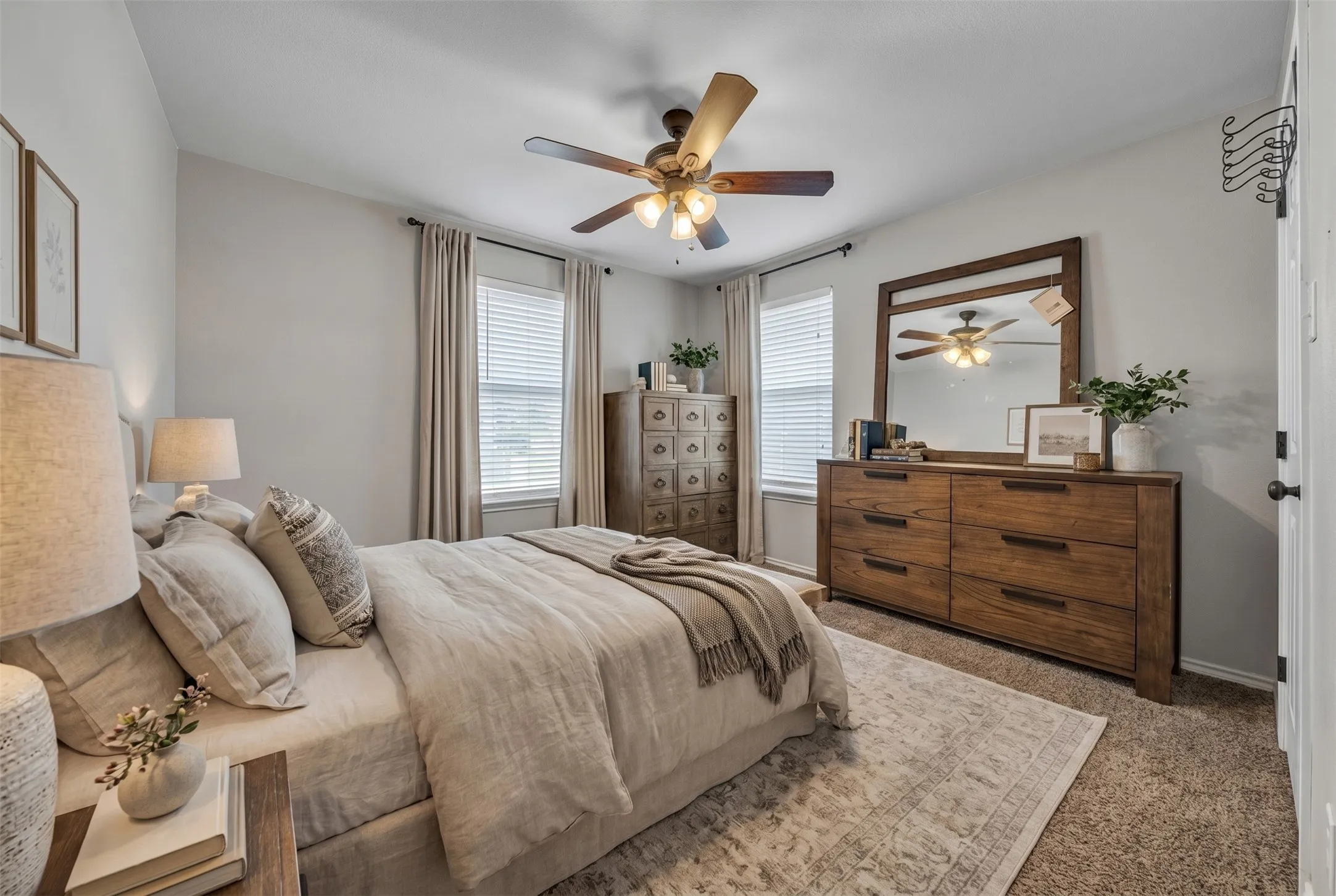Carpeted bedroom featuring light gray wall paint and a ceiling fan with integrated lighting