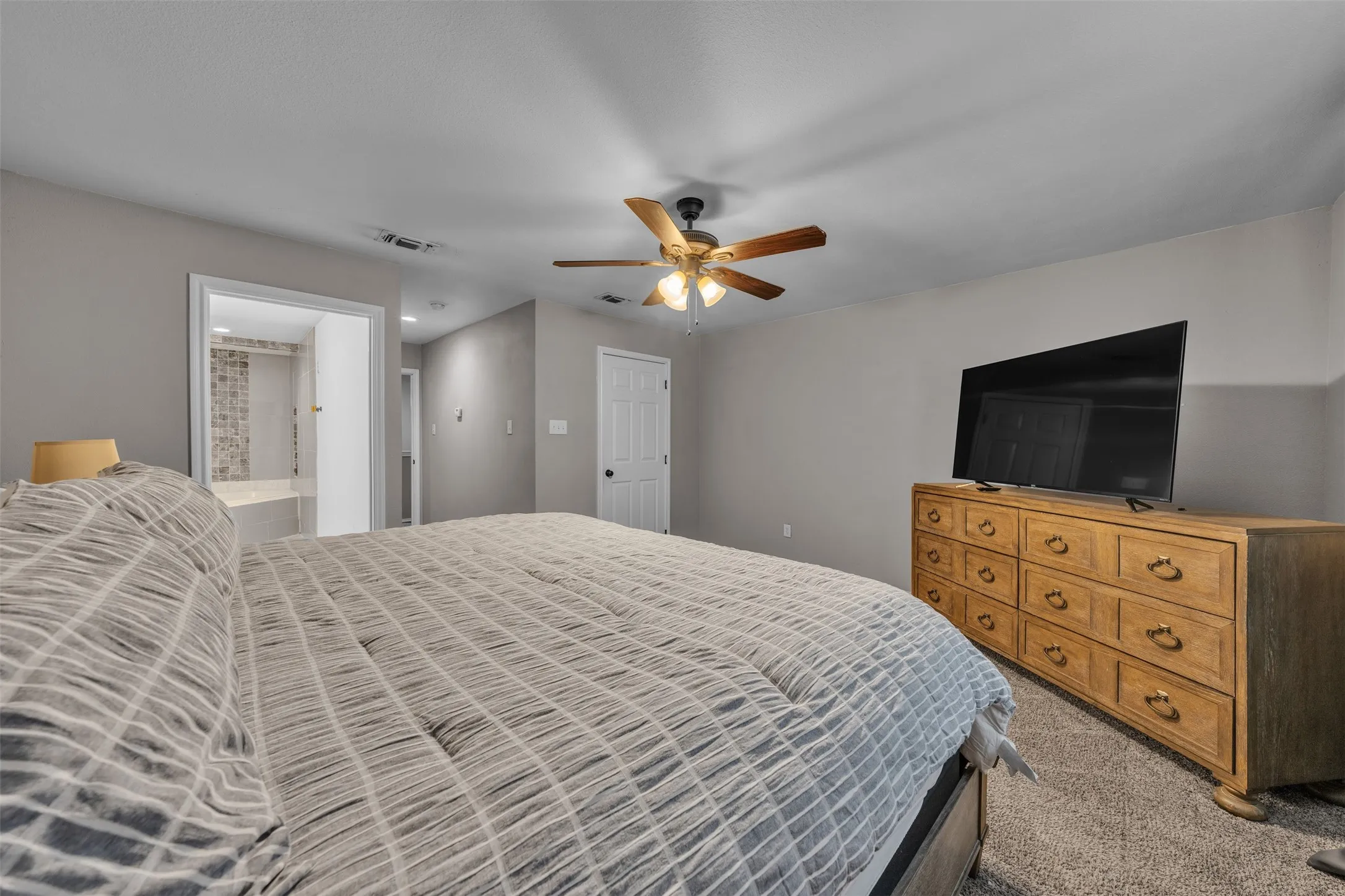 Spacious room featuring gray walls and neutral-toned carpeting