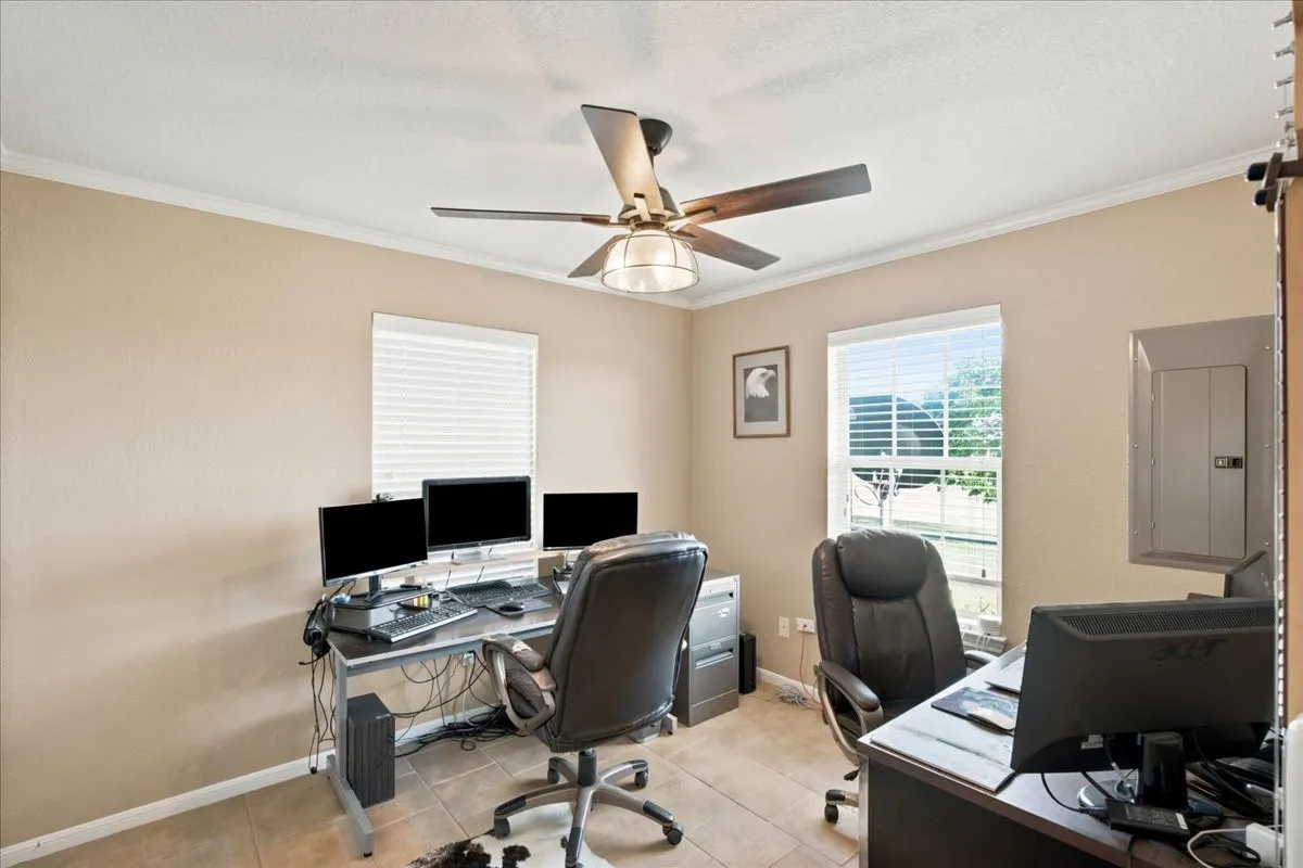 Neutral tone walls with crown molding and tile flooring