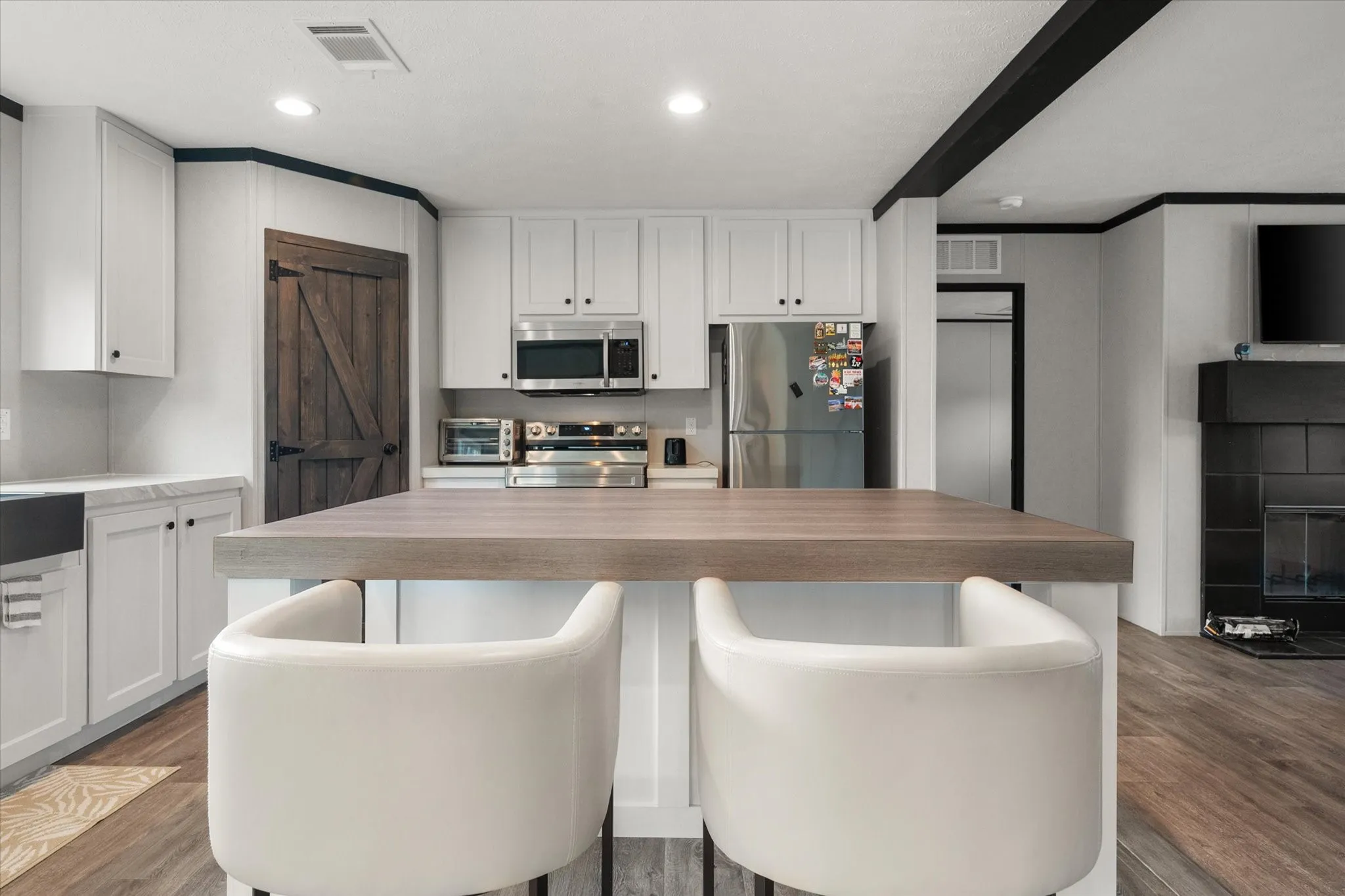 Open-concept kitchen featuring an island and built-in stainless steel microwave