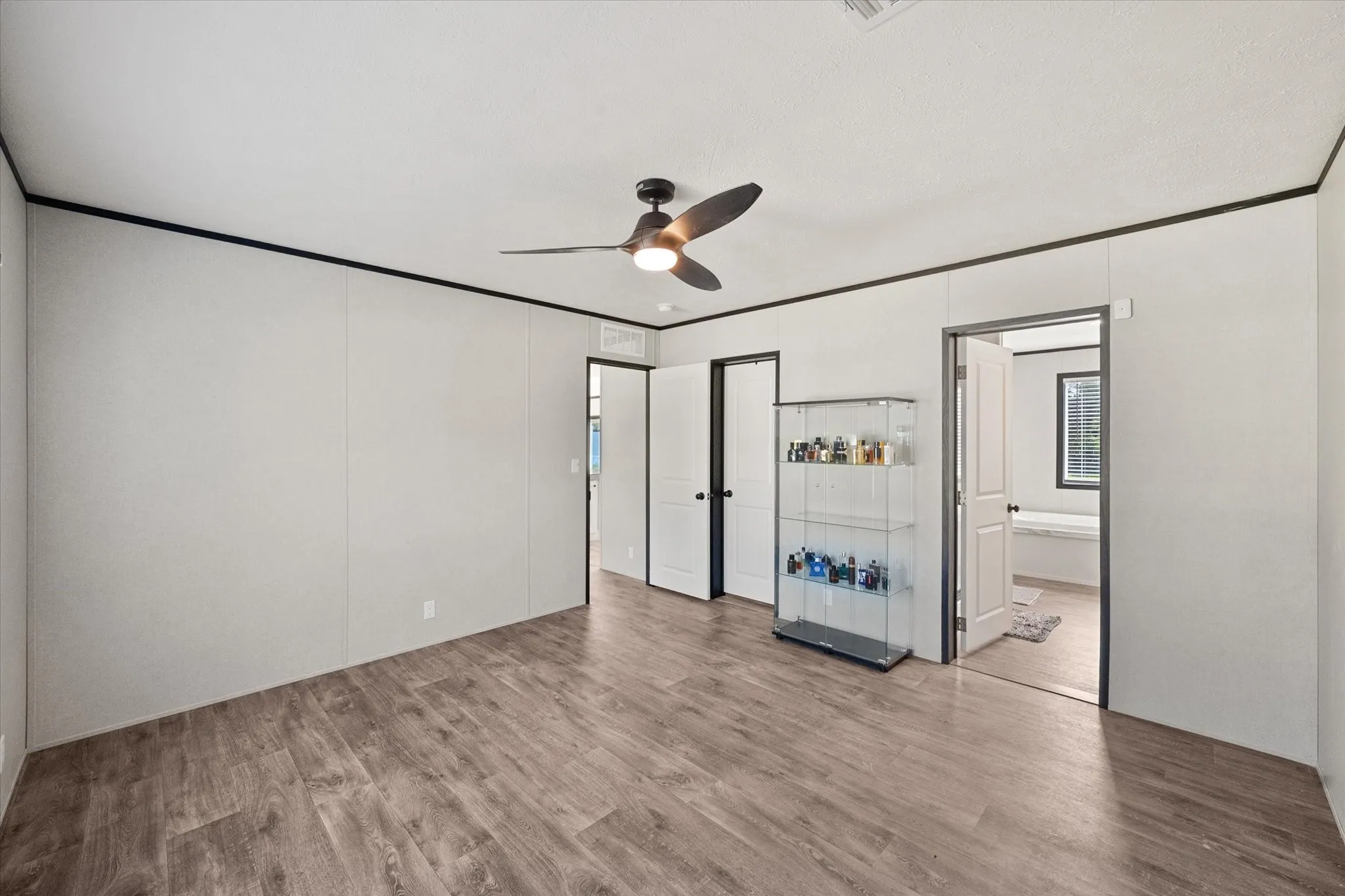Spacious primary bedroom featuring wood-finish flooring.