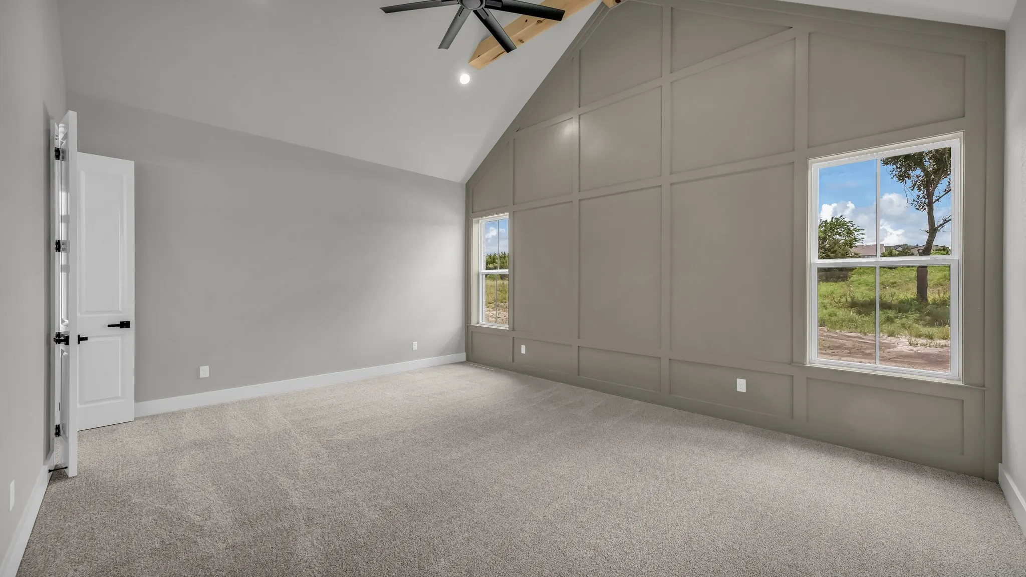 Vaulted ceiling with an exposed wood beam, contemporary ceiling fan, and recessed lighting