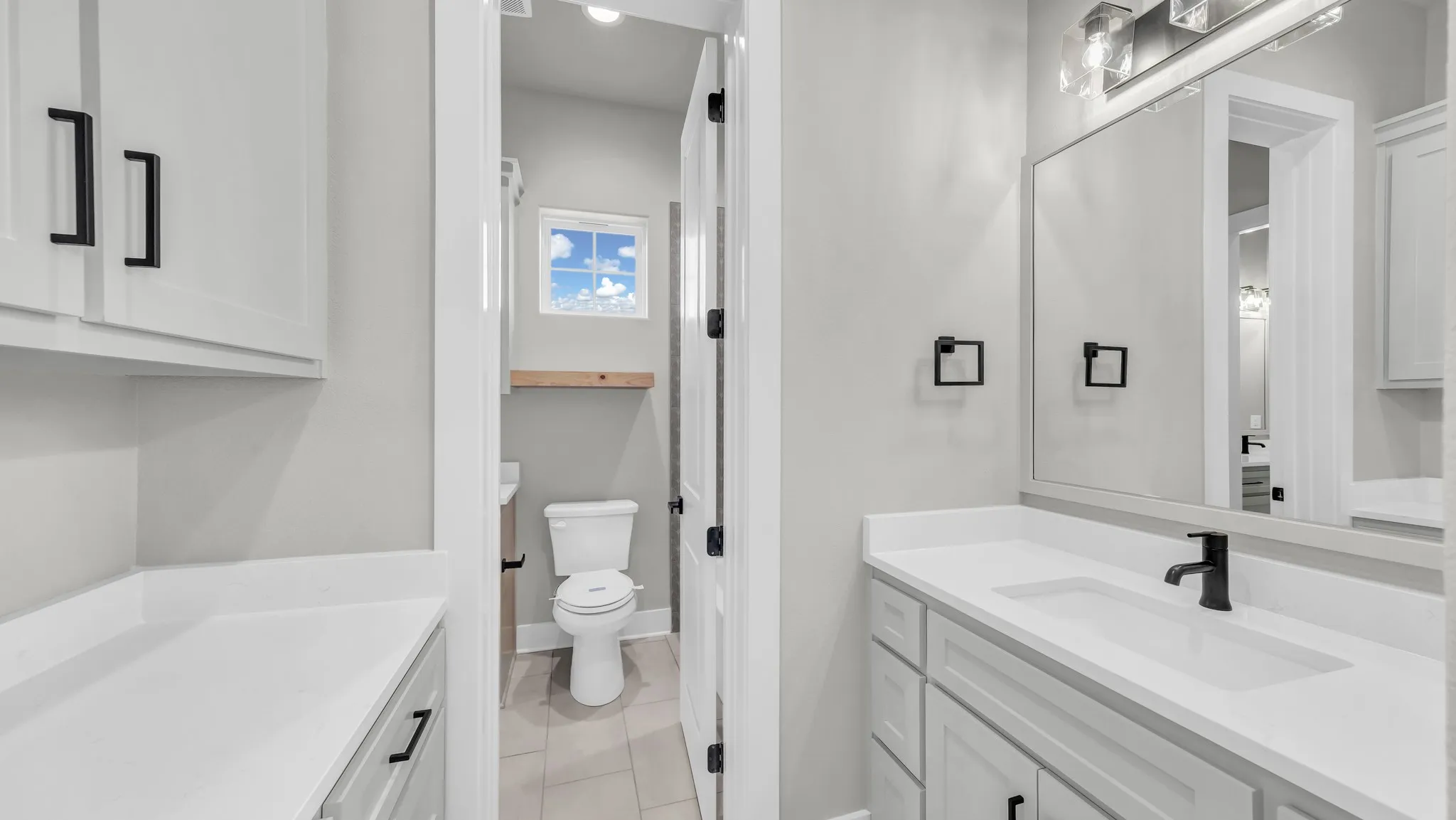 Bathroom vanity featuring white cabinetry, a white countertop, and a rectangular undermount sink with a matte black faucet