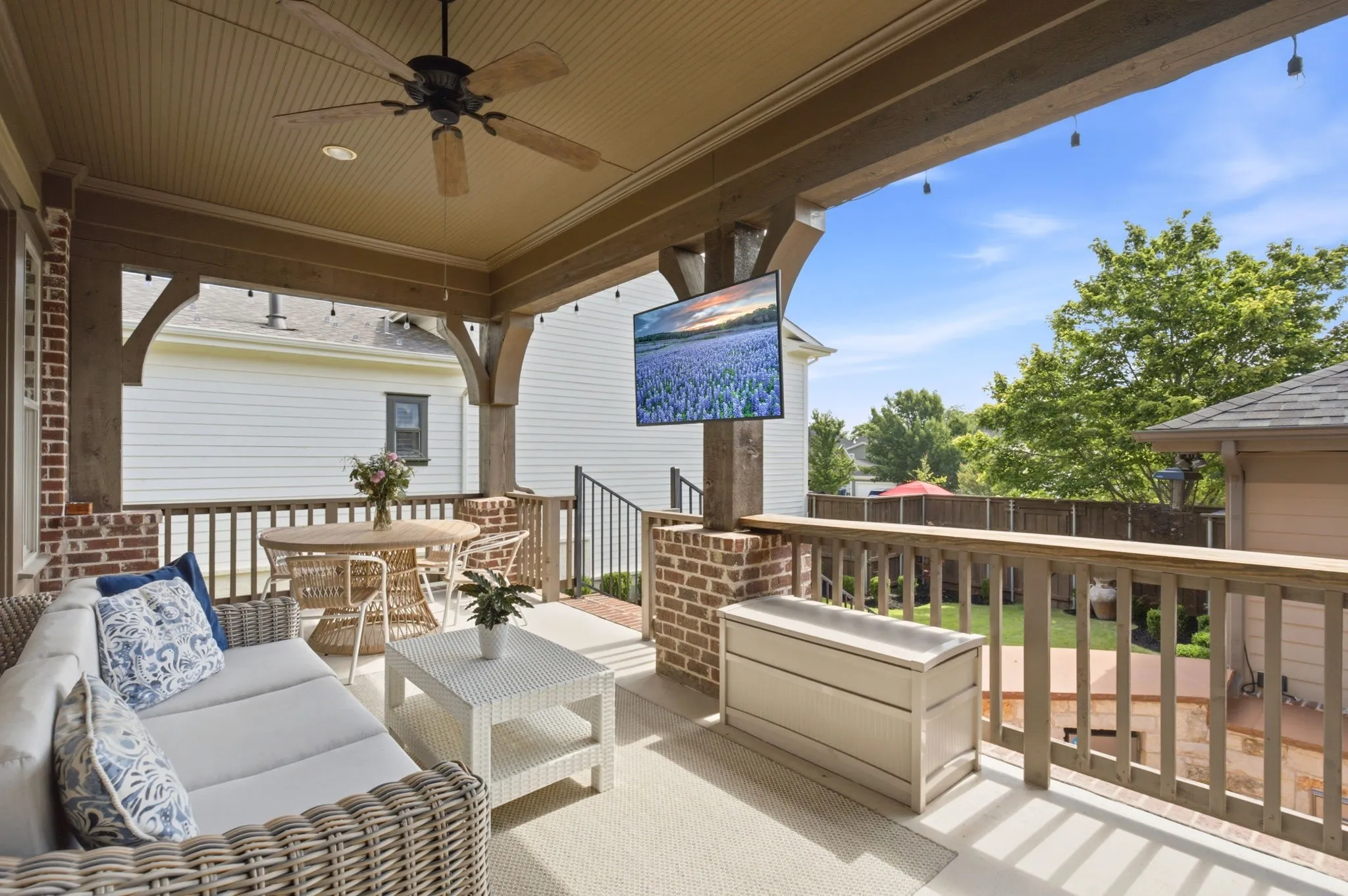 This spacious covered patio features a beautifully designed raised deck that offers a perfect vantage point for overlooking the lower-level outdoor kitchen area, the expansive entertainment space, and the meticulously manicured backyard retreat.