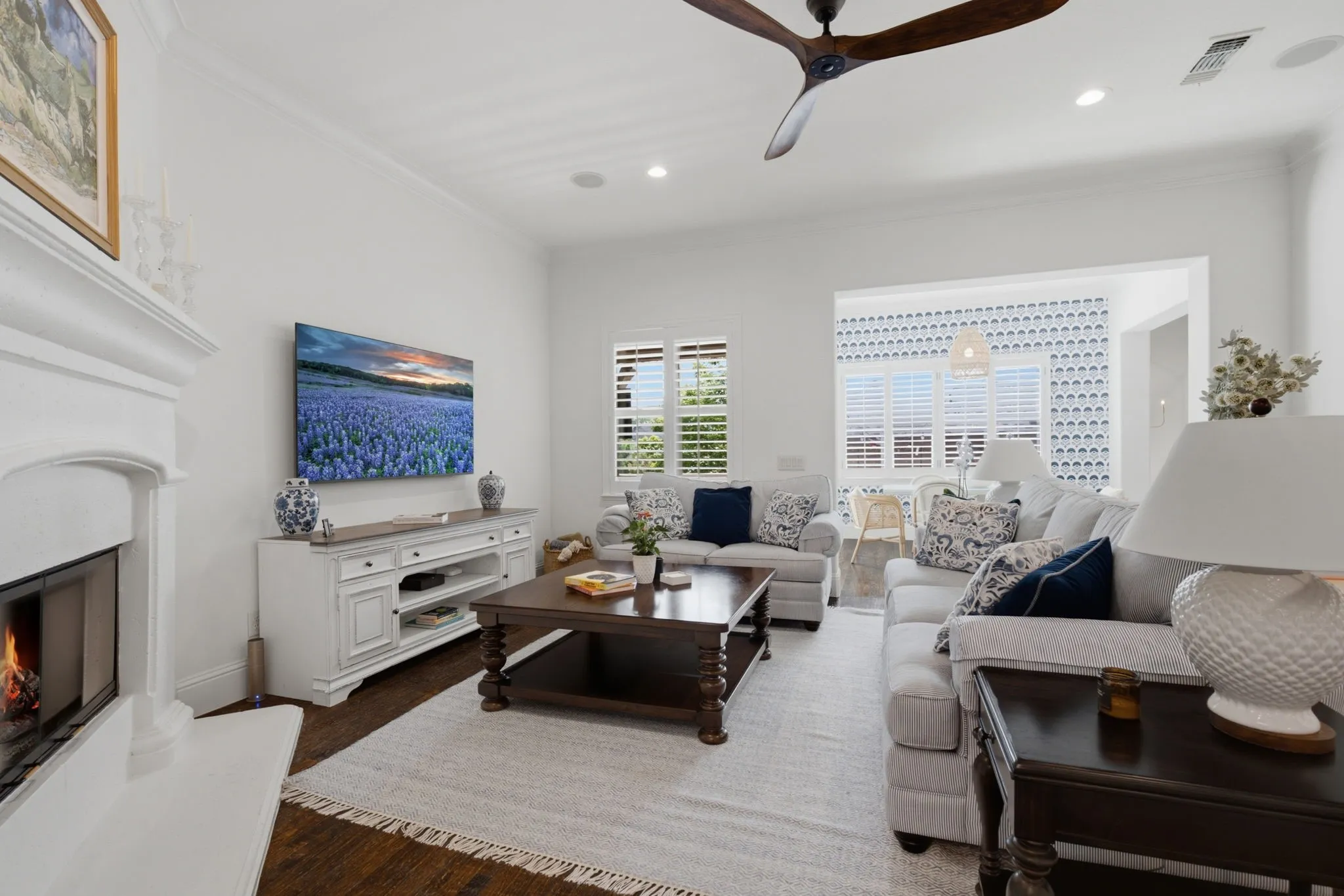 This expansive and light-filled family room offers an exceptionally comfortable atmosphere, featuring a charming fireplace as the focal point of the space and a convenient, seamlessly integrated breakfast nook located immediately adjacent for effortless daily living.