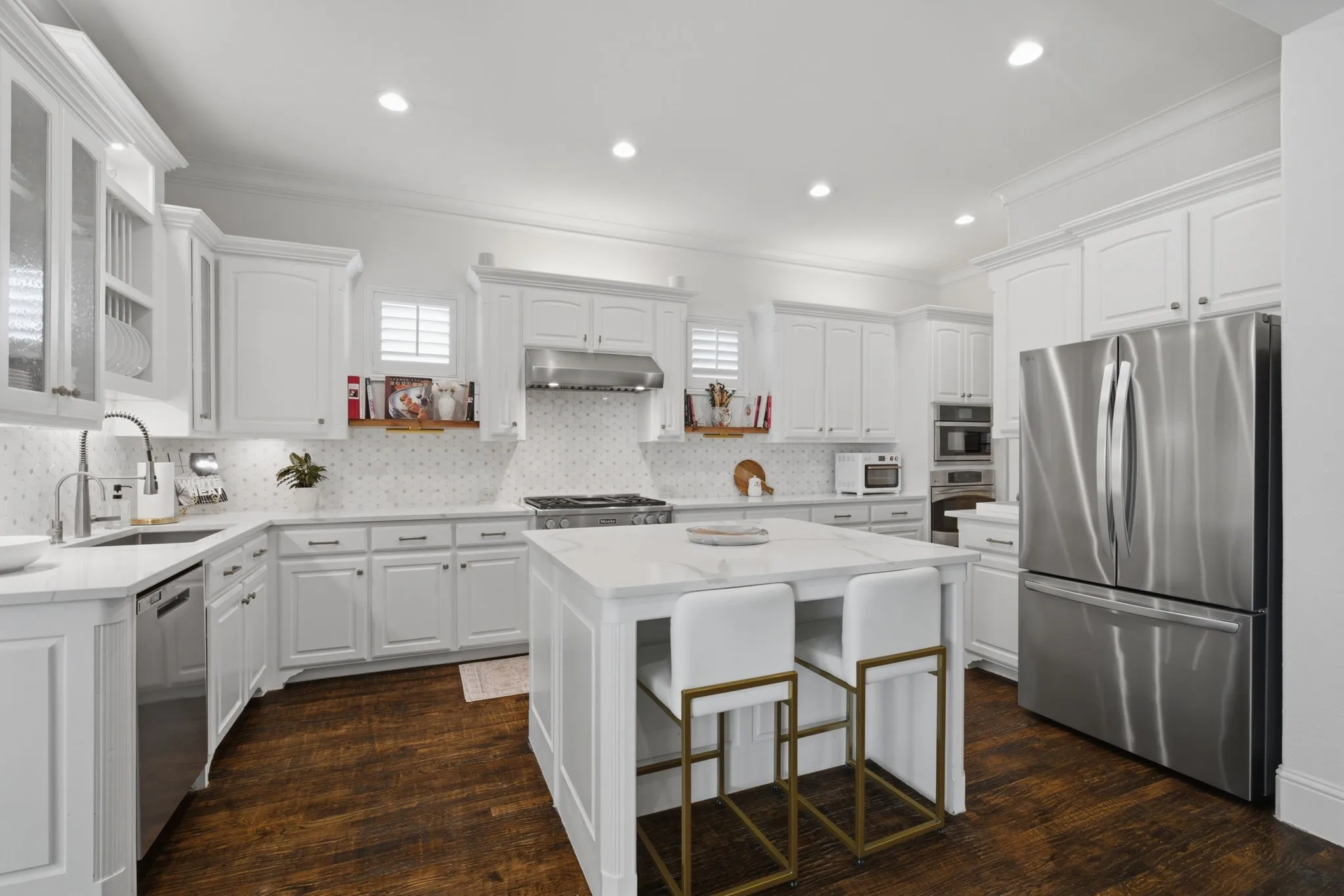 This stunning chef-inspired kitchen features high-end stainless steel appliances, including a professional-grade gas cooktop perfect for culinary enthusiasts. The spacious central island provides an ideal workspace for meal preparation or casual dining, all beautifully complemented by rich, gleaming hardwood floors that add warmth and elegance to the heart of the home.