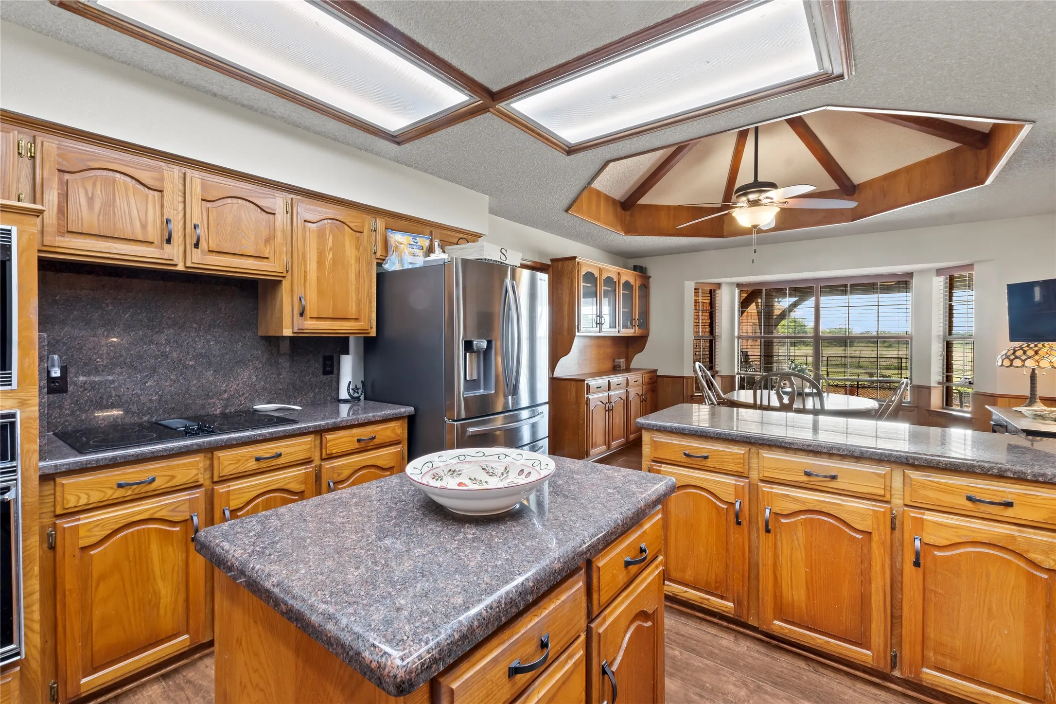 Spacious kitchen featuring a central island, wood-finish flooring, and ample cabinetry