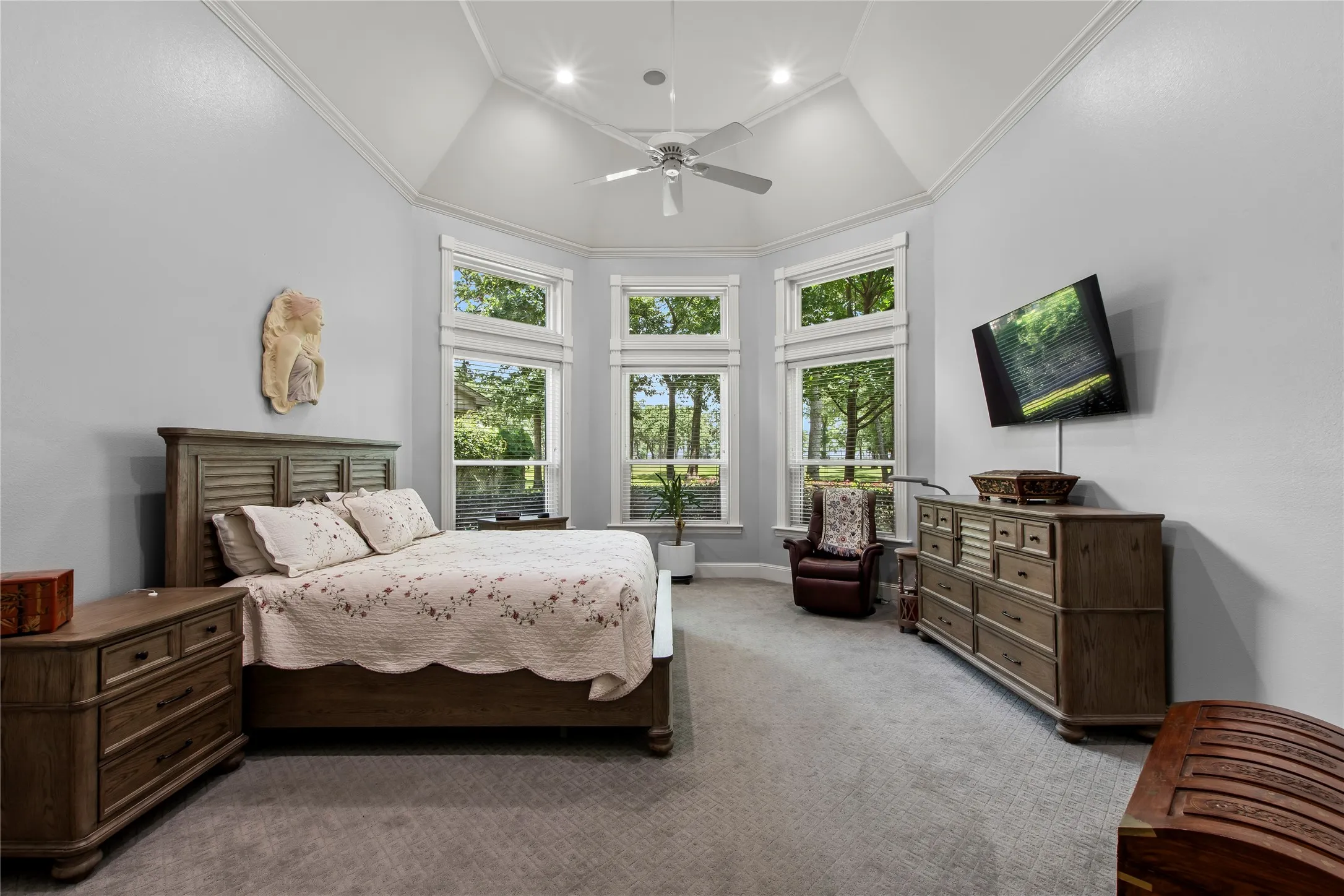 Primary bedroom with windows looking out to golf course