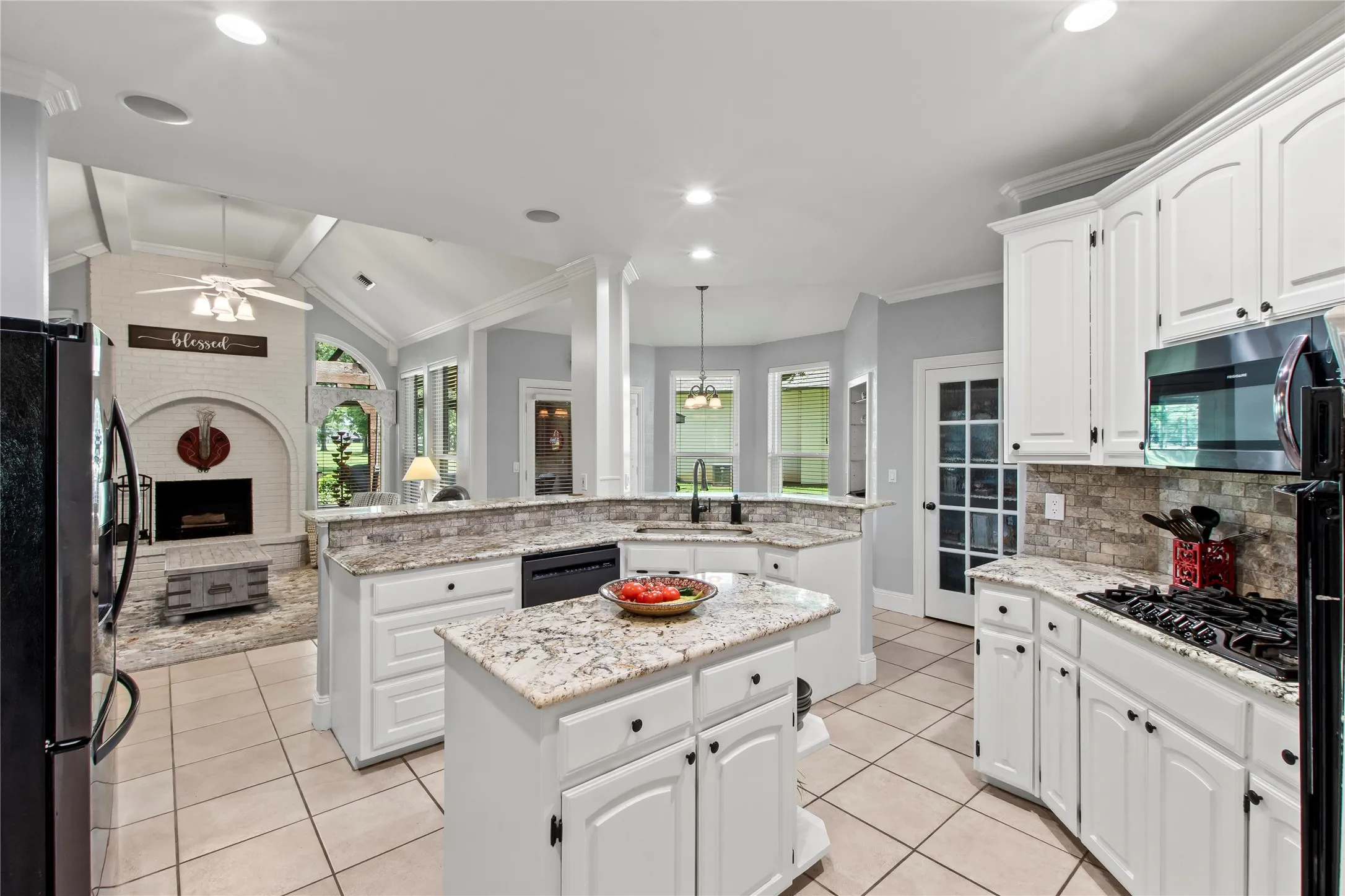Open kitchen with gas cooktop and lots of cabinets.