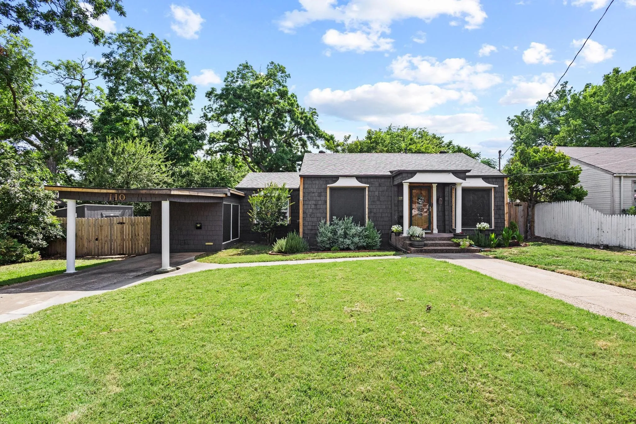 Large grassed front yard with single carport