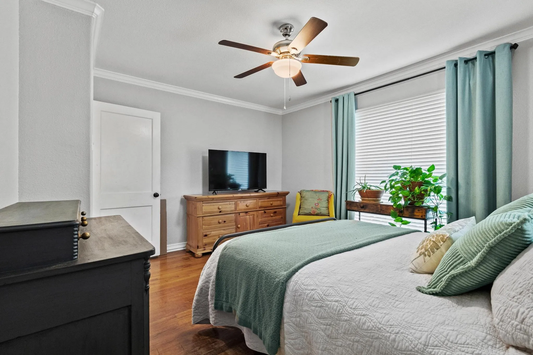Large bedroom with natural light and hardwood flooring throughout