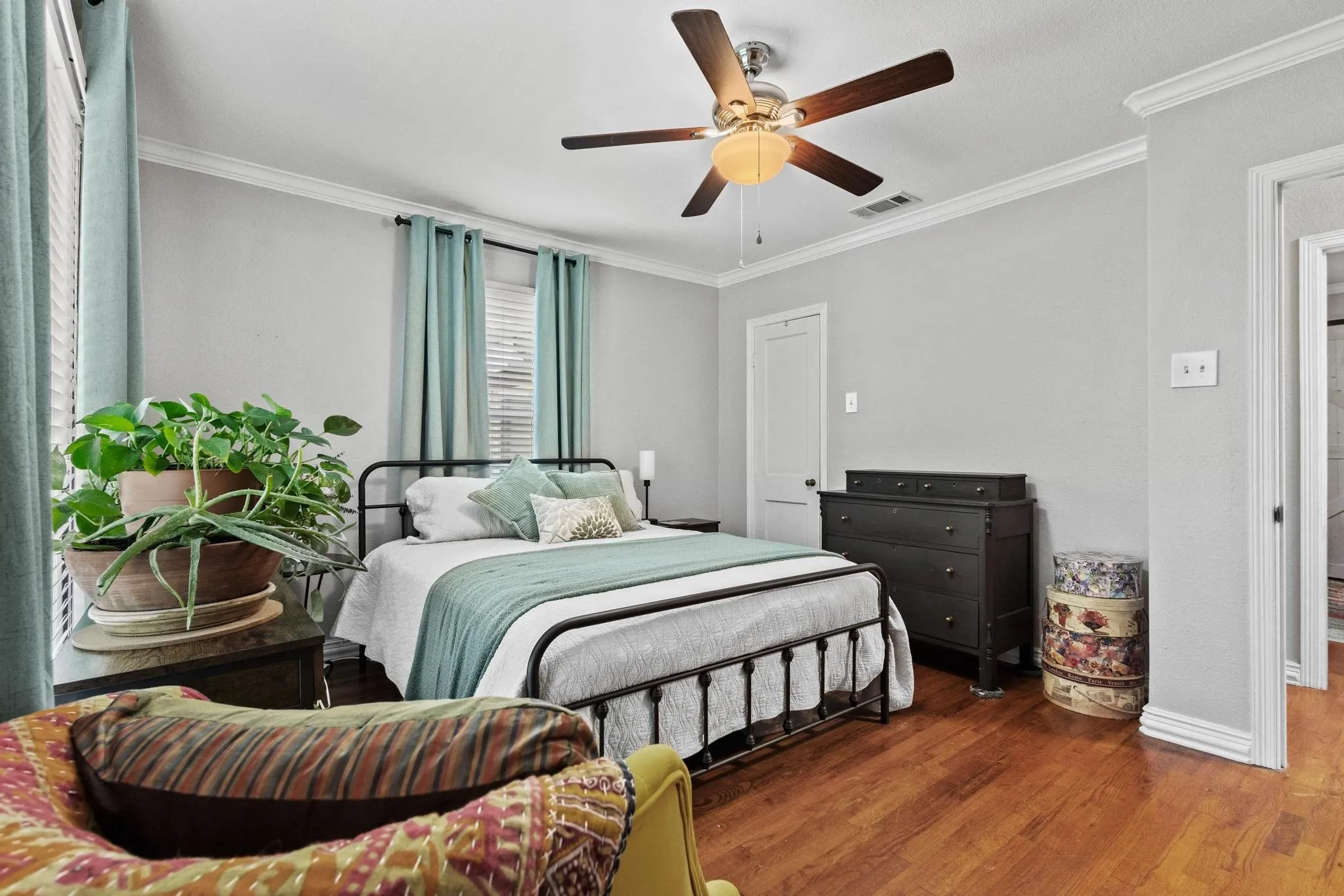 Large bedroom with natural light and hardwood flooring throughout
