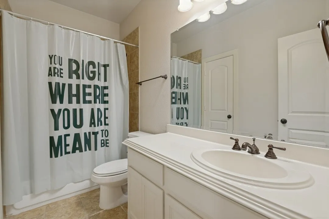 Bathroom vanity featuring a single integrated sink, bronze-finish faucet, and a large wall-mounted mirror