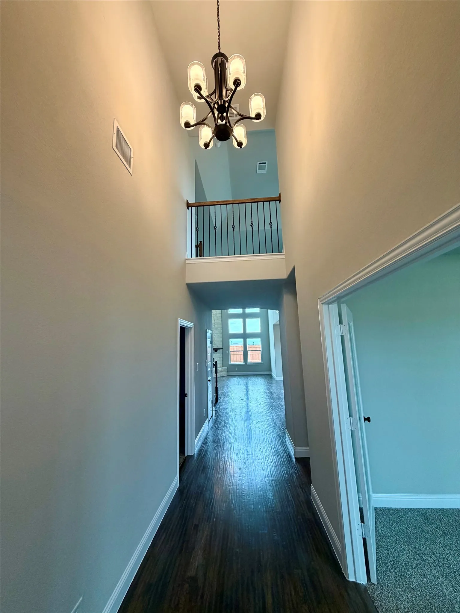 Cathedral entry with elegant chandelier and REAL rich hardwood floors